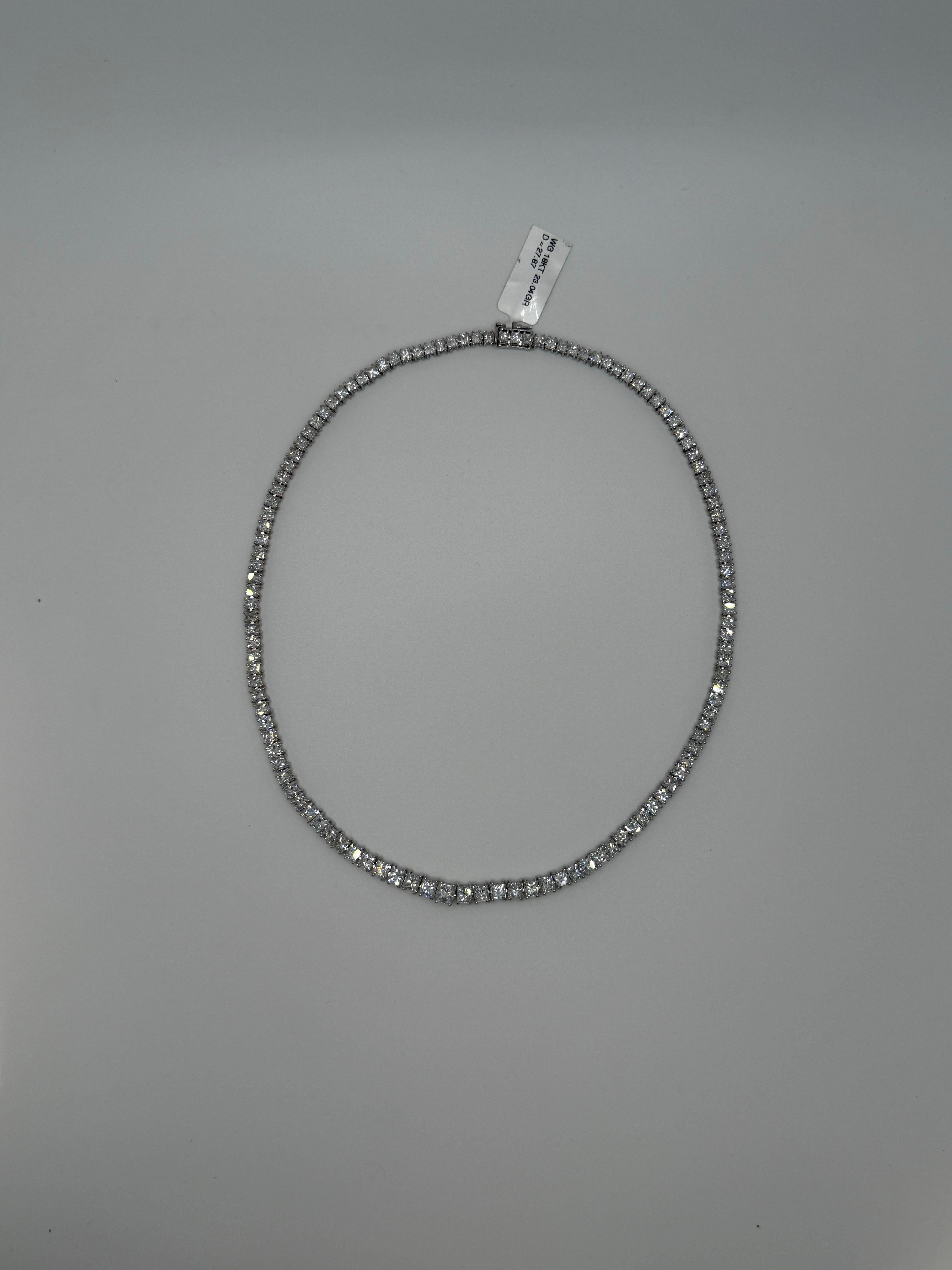 Ce collier de diamants saisissant est une version raffinée du style tennis classique. Il est réalisé en or blanc 18 carats et serti de 27,87 carats de diamants brillants de taille princesse. Chaque diamant est soigneusement apparié et aligné, créant
