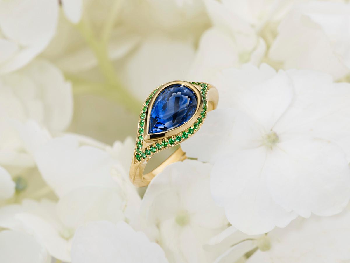 A 2.79 ct Ceylon sapphire, pear shaped; encircled with the finest tsavorites. A combination of old world techniques that only a hand made piece of fine jewelry will offer- hand carved wax mold, which is cast and then expertly hand set with pavé