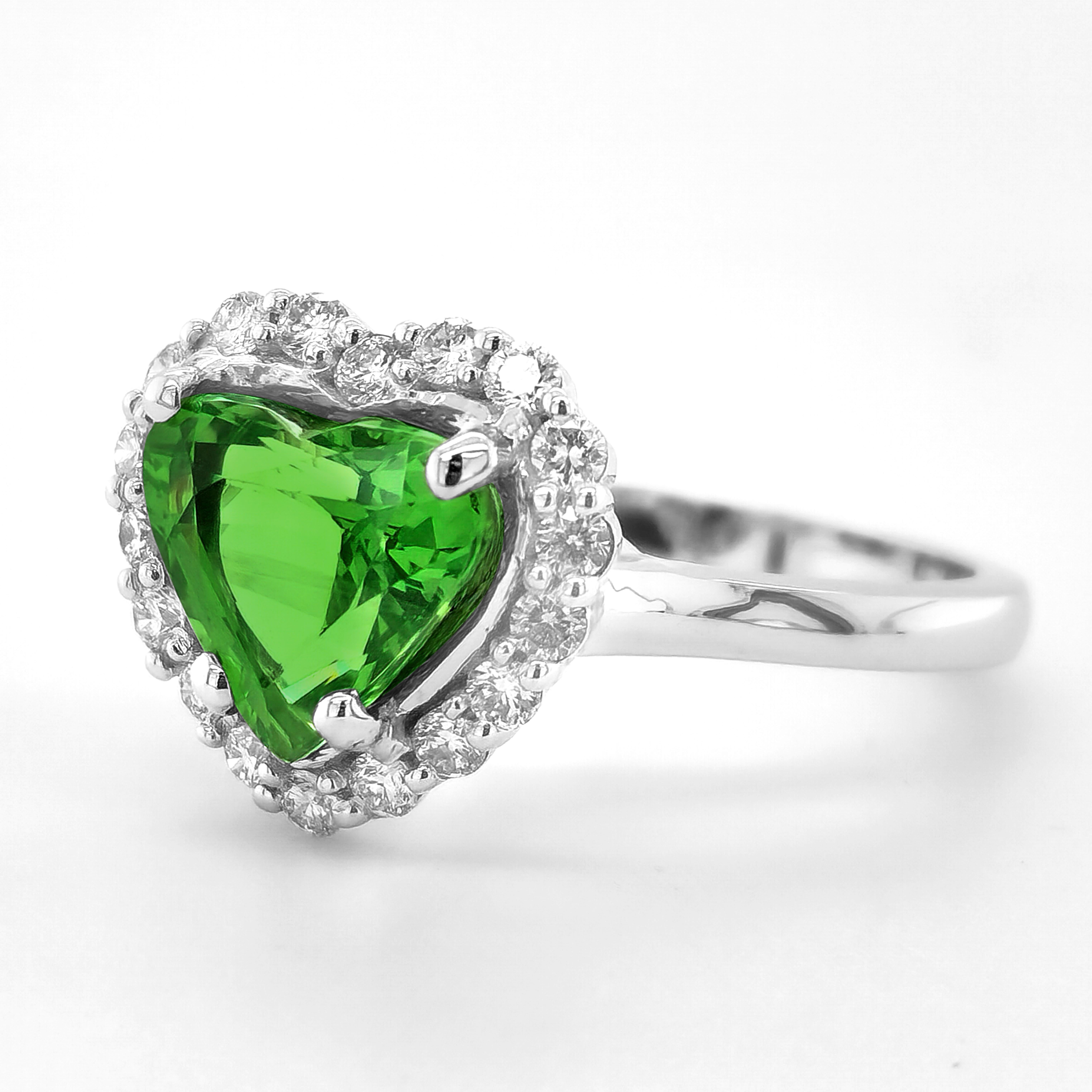 Set with a 2.79 carat Tsavorite Garnet, the richly colored gem is a riot of green. Deep, intense greens are know to symbolize luck and here is an exceptionally clear gem that has an internal fire that sets it apart. A heart shaped, paired with