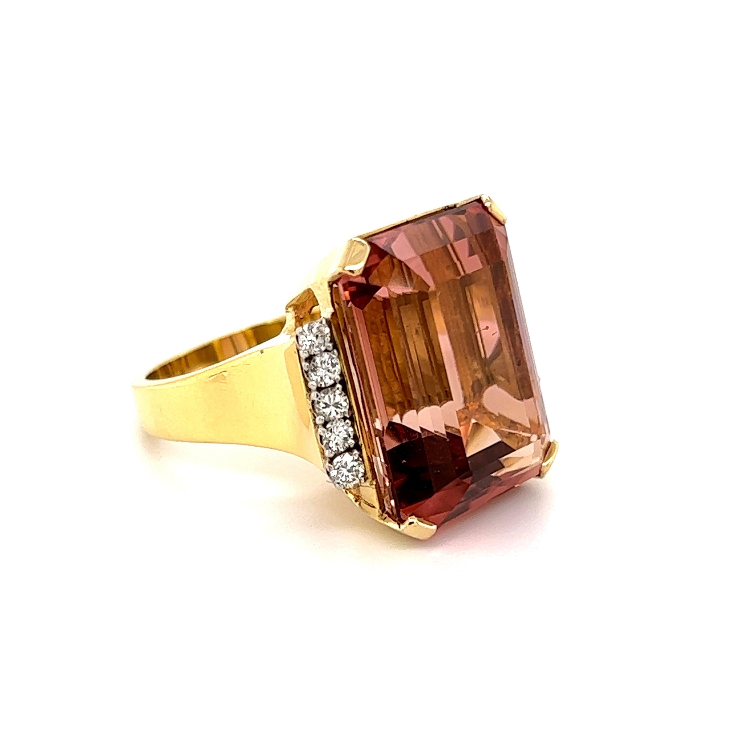 Simply Beautiful! Finely detailed Rare Peach Tourmaline and Diamond 18K Gold Cocktail Ring. Centering a securely nestled Emerald-Cut Peach Tourmaline, weighing approx. 27.90 Carats either side set with Round Diamonds; weighing approx. 0.40tcw.