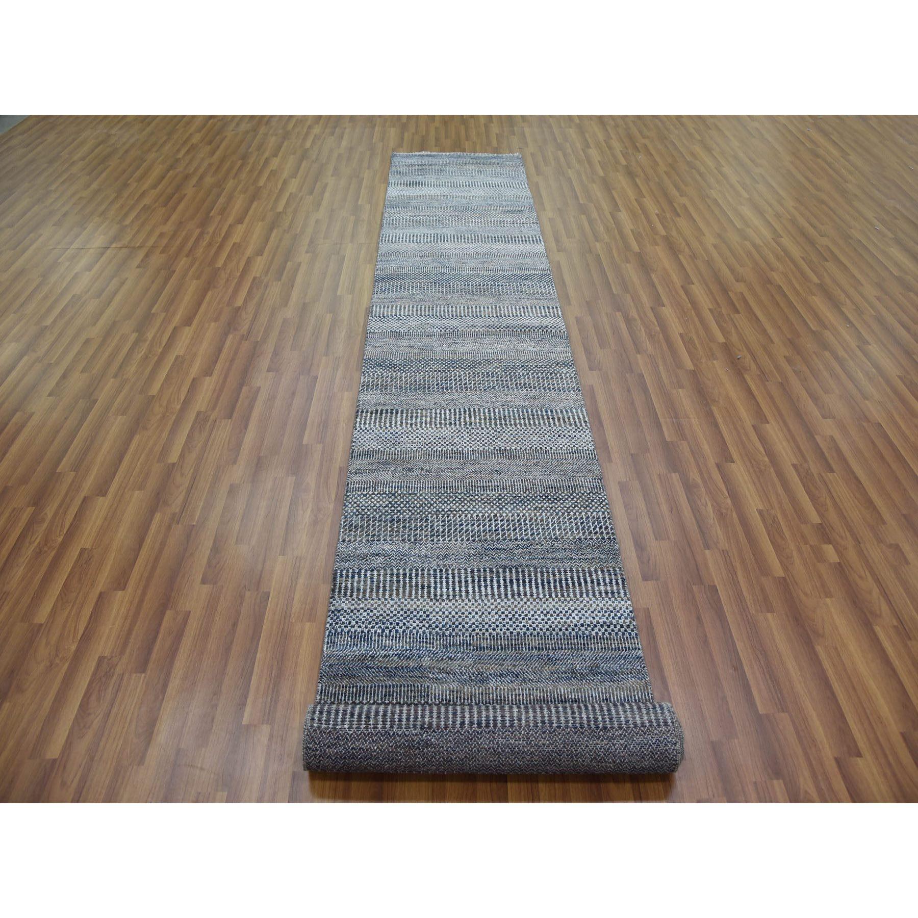 Se trata de una auténtica alfombra oriental de hierba Gabbeh, de diseño moderno, anudada a mano en lana y seda, de color gris marengo y densamente tejida. Ha sido anudada durante meses y meses con técnicas artesanales de tejido centenarias por