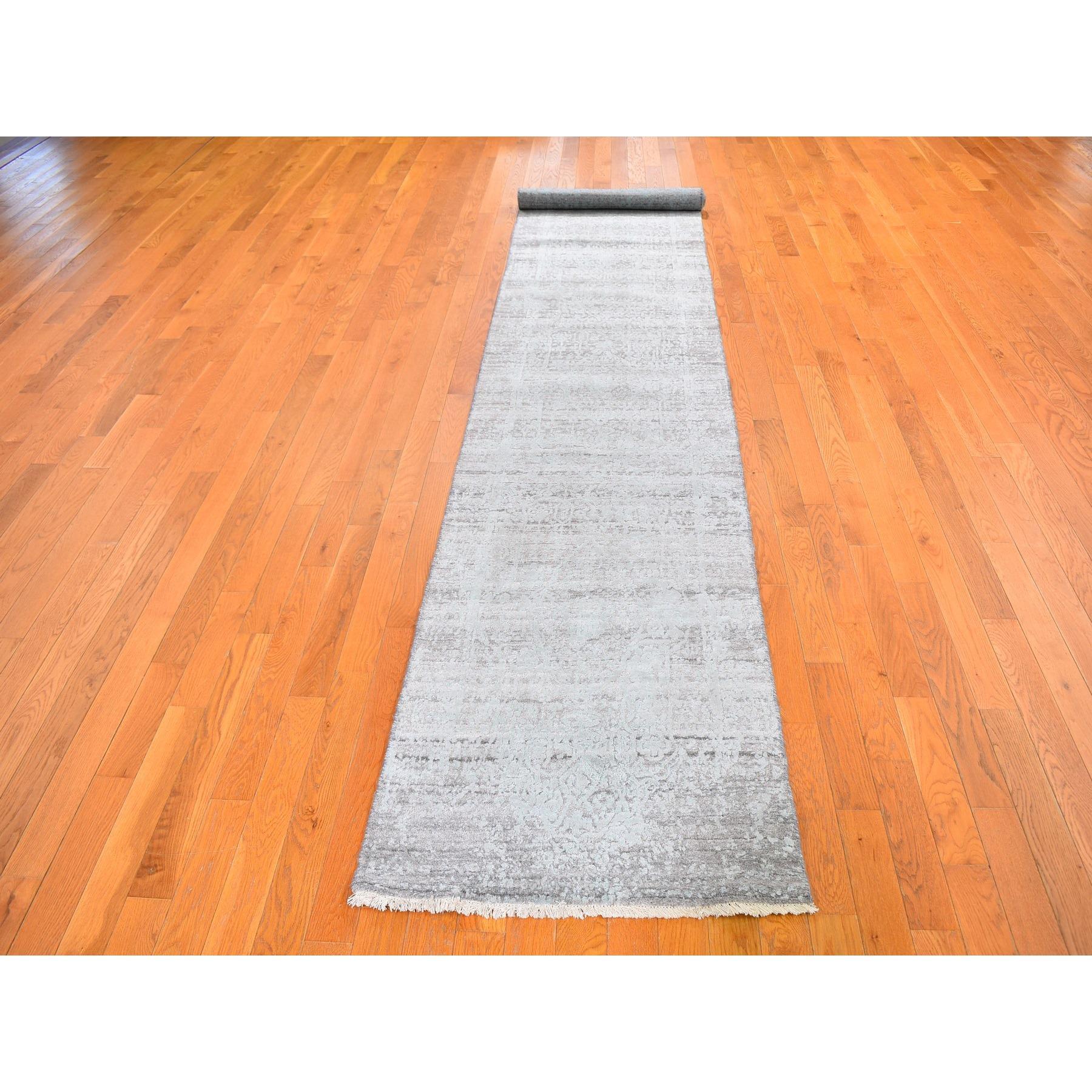 Il s'agit d'un véritable tapis d'Orient, unique en son genre, en laine et soie, ton sur ton, à motif persan brisé, noué à la main. Il a été tissé pendant des mois et des mois selon les techniques séculaires de l'artisanat persan par des artisans