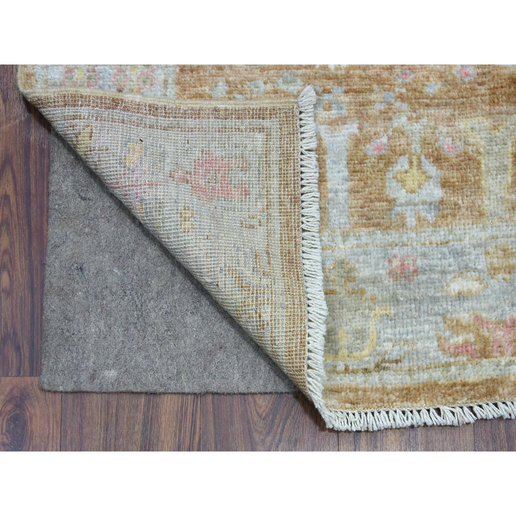 Il s'agit d'un véritable tapis noué à la main, unique en son genre, en angora Oushak marron amande avec des motifs de cyprès et de saules délavés, en laine souple et flexible. Il a été noué pendant des mois et des mois dans le cadre d'un tissage