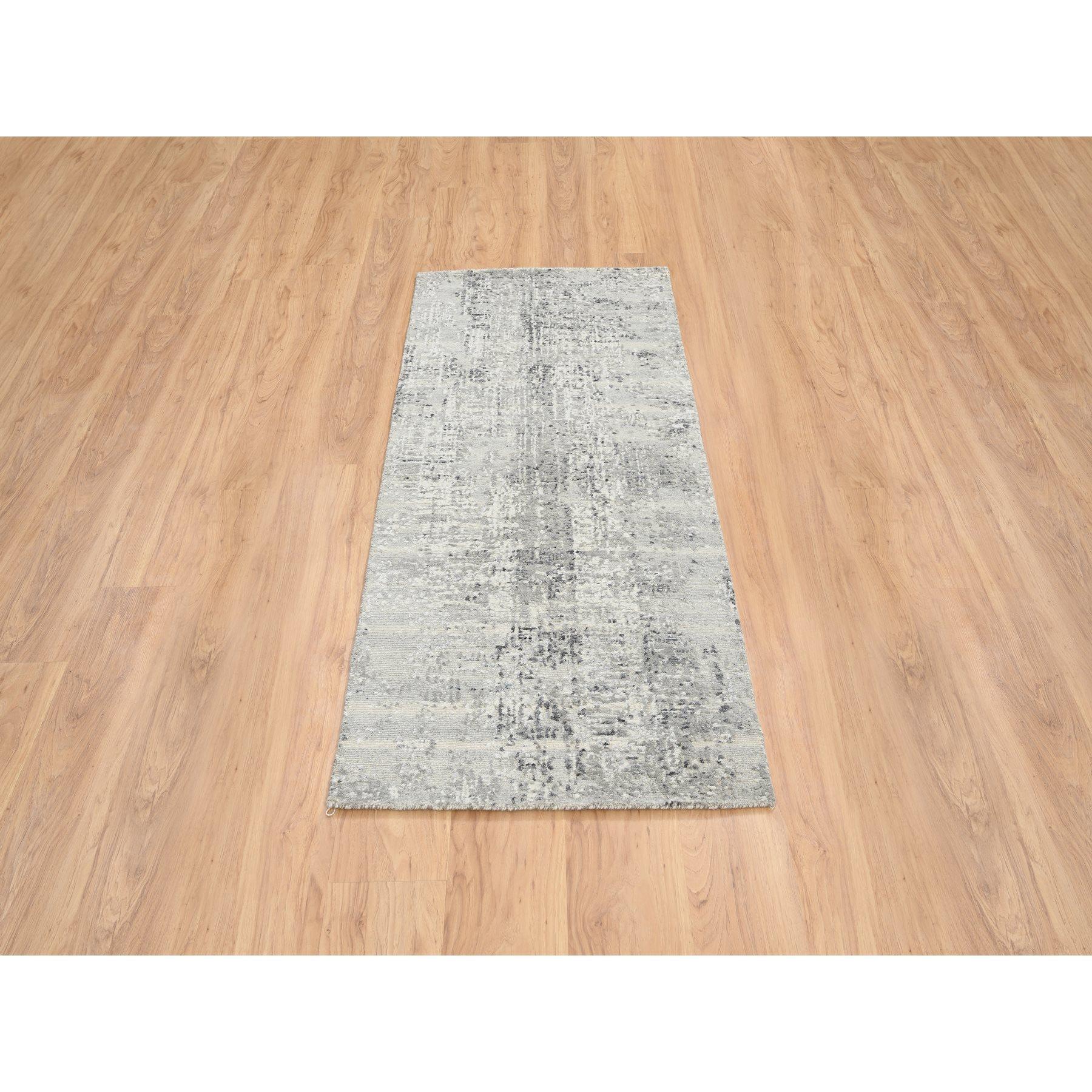 Il s'agit d'un véritable tapis d'Orient gris clair, en laine naturelle non teintée filée à la main, noué à la main, au design moderne. Il a été noué pendant des mois et des mois selon des techniques de tissage séculaires par des artisans