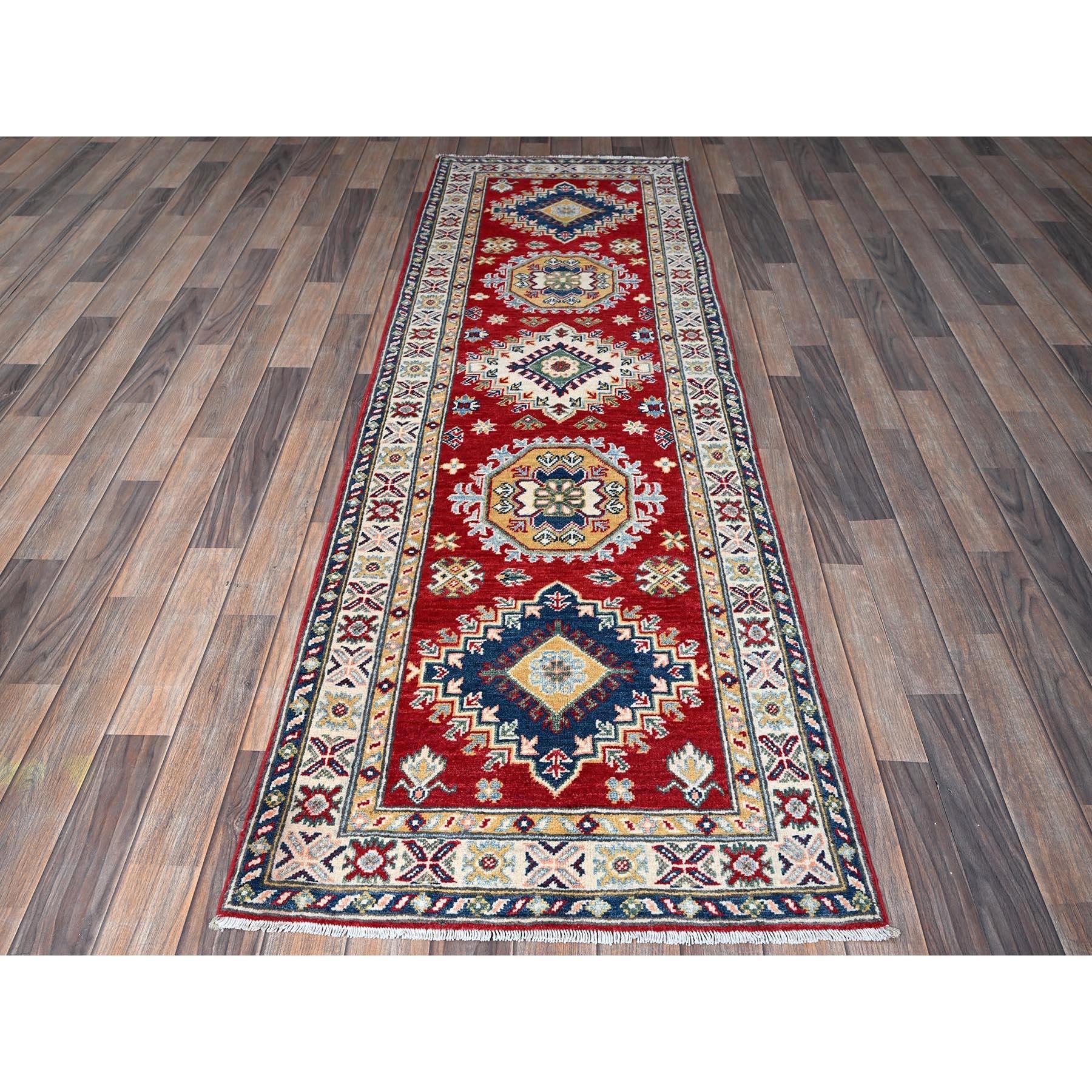 Rouge Arsenal, Kazak avec motifs de médaillons tribaux, noué à la main, laine douce et veloutée, teintures végétales, tissage plus dense, chemin de randonnée, tapis d'Orient
Matières premières : Laine
Latex : Pas de poils 
hauteur : 0,25