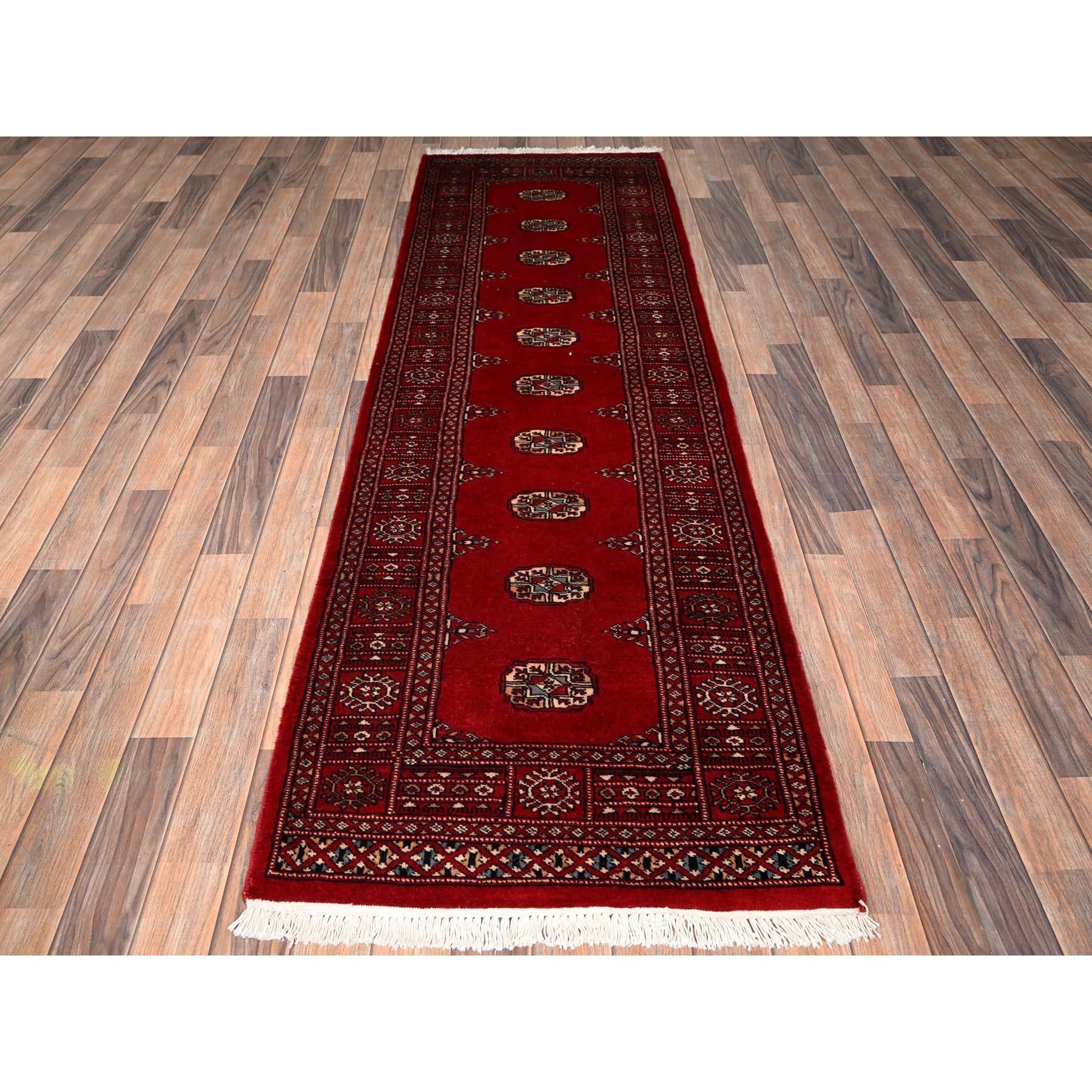 Crimson Red, Hand Knotted, Princess Bokara with Tribal Medallions, Soft and Shiny Wool, Narrow Runner, Oriental Rug
Primary materials: Wool
Latex: No Pile 
height: 0.25 Inches
Style: Traditional
Primary color: Red
Secondary colors: Blue, Peach,