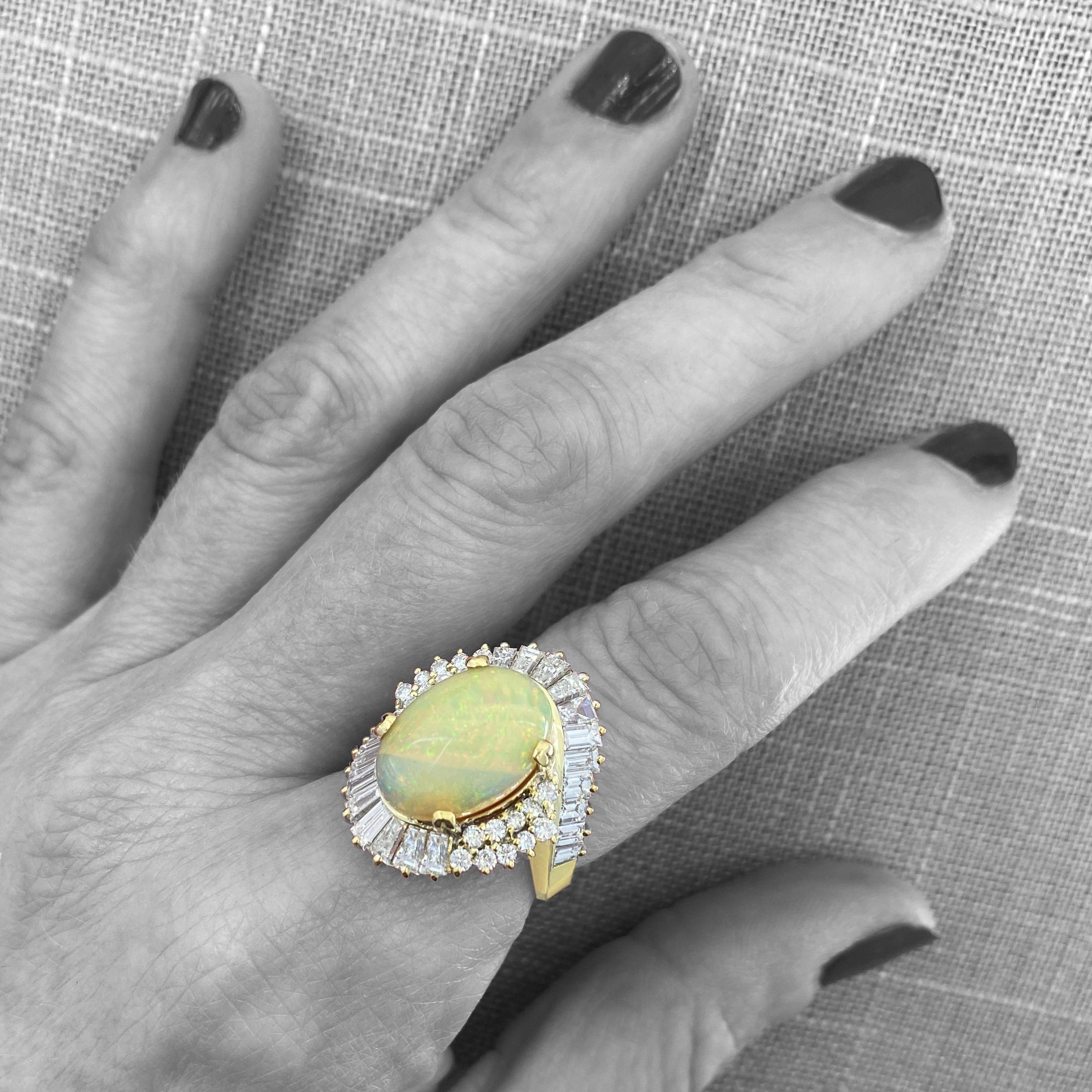 This amazing ring, probably a custom piece from the 1960s, originally featured a star sapphire, but we wanted the stone for a different ring, so we replaced it with a stunning Ethiopian white opal.  

As you can see in our photos, the dominant color