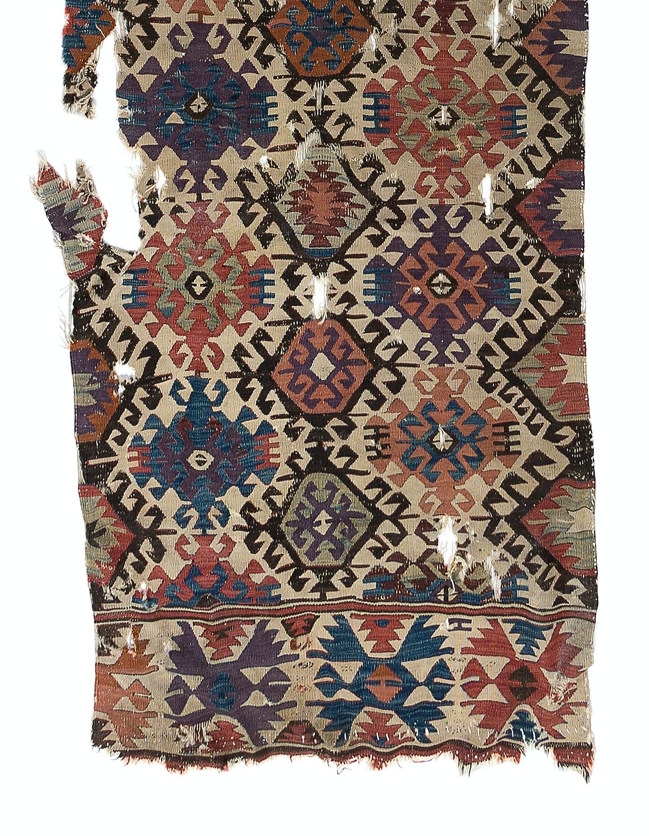 Embark on a journey through time and tradition with this exquisite Antique Turkish fragment distressed kilim, a rare artifact dating back to the 18th century. Crafted with meticulous skill and artistry by Anatolian weavers over three centuries ago,