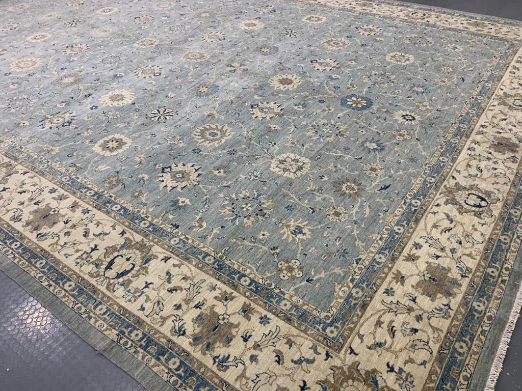 A huge sized rug with design in style of Farahan.
This beautiful rug was hand knotted to fit 21st century interior needs. The background is in an elegant blue gray beige color with floral designs.
Farahan design rugs are very looked after since they