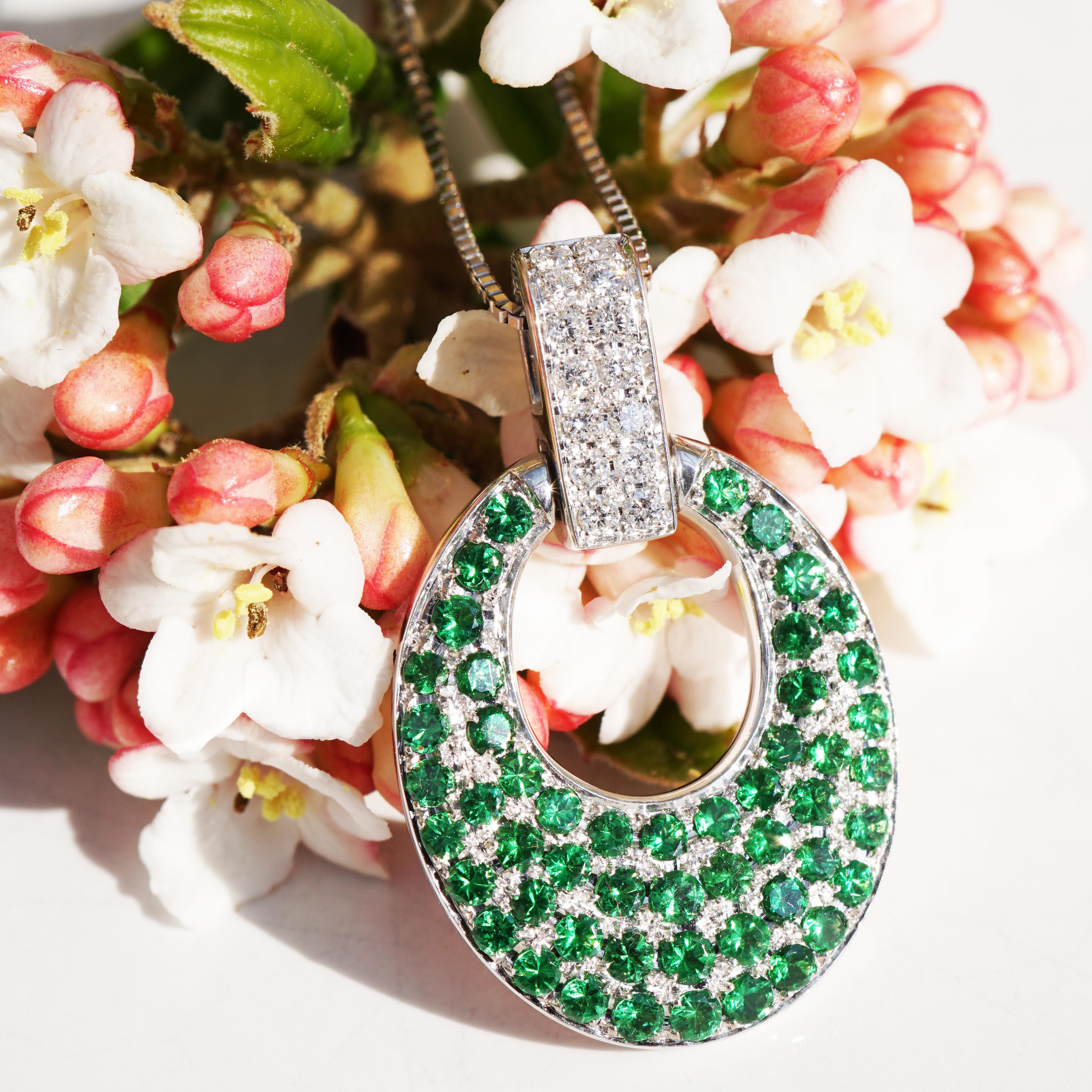 massive pendant in luxury quality, rectangular loop set with full-cut brilliant-cut diamonds total approx. 0.16 ct, TW-W (fine white-white) / VS (very small inclusions), heavy oval muggle pendant plate set with the finest tsavorites (green garnet)
