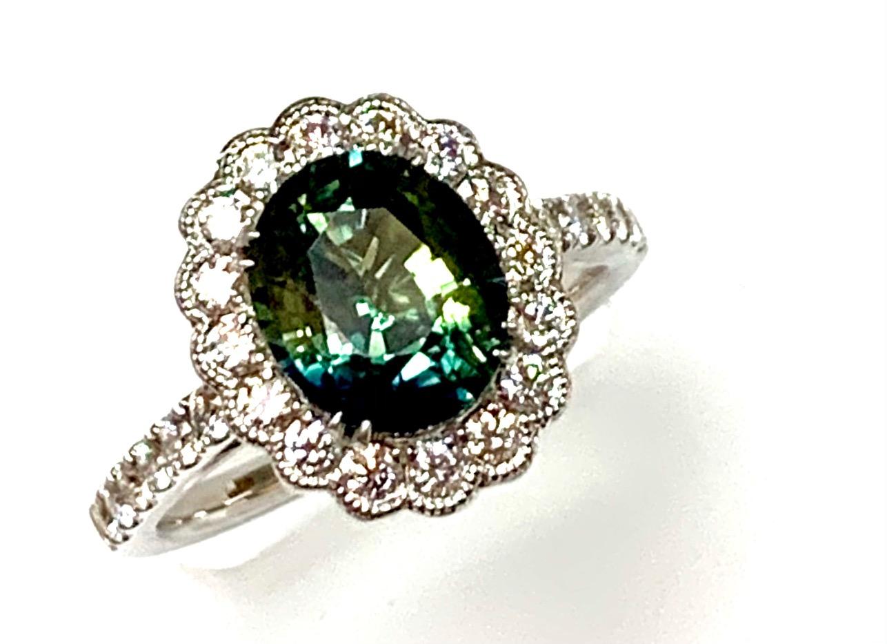 2.80 Carat oval green/blue/ bi color sapphire set in 18k white gold ring with 0.63 carat round diamonds around it and half way on the shank .