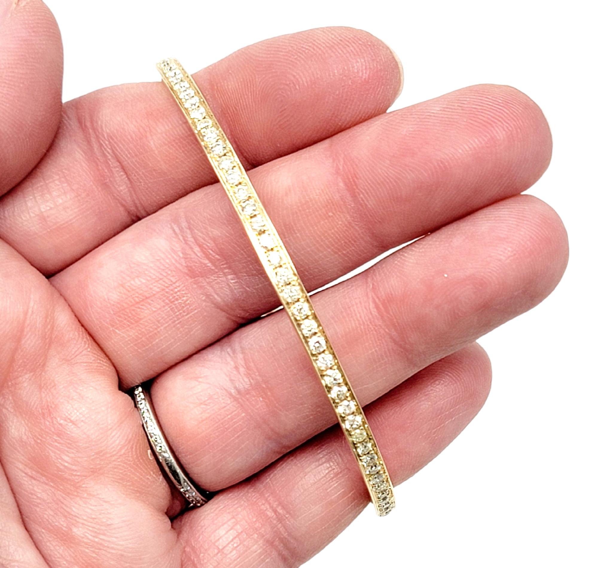 Simple yet stunning diamond eternity bracelet. This delicate paved bangle bracelet boasts an ultra feminine feel, while the sleek simplicity gives it a modern elegance. It features 93 natural round brilliant diamonds, K-L-M in color and SI-I2 in