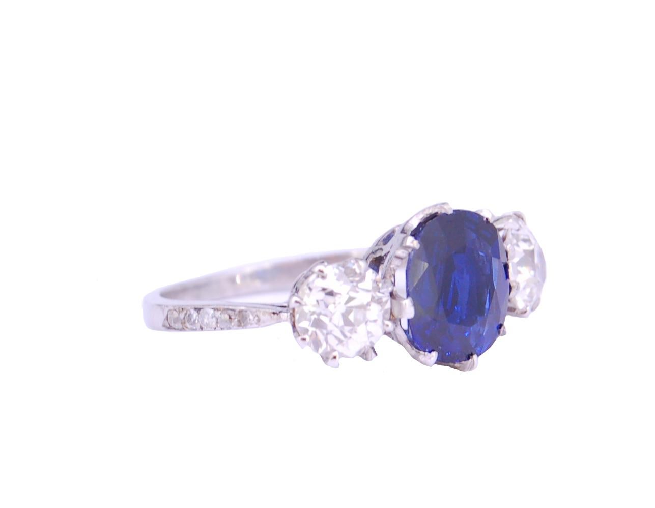 2.80 ct. BURMA BLUE SAPPHIRE AND DIAMOND 3-SOTNE RING, central set with a blue sapphire of 2.80 ct. flanked by diamonds totalling 1.60 ct. Size O. 3.8 grams. Accompanied by GCS London report No. 80237-32 stating that the 2.80 ct. blue sapphire is