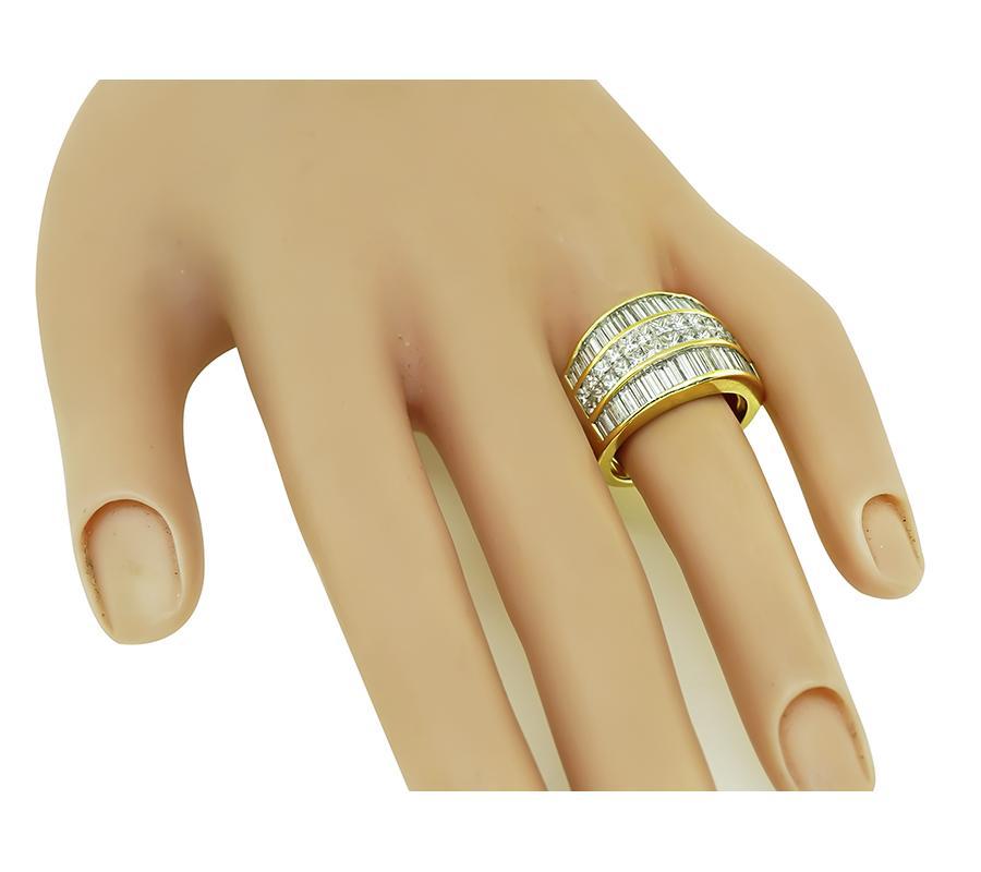 This is a fabulous 18k yellow gold ring. The ring is set with sparkling baguette and princess cut diamonds that weigh approximately 2.80ct. The color of the diamonds is H with VS clarity. The ring has a tapering width from 7.5mm to 14.5mm. The ring
