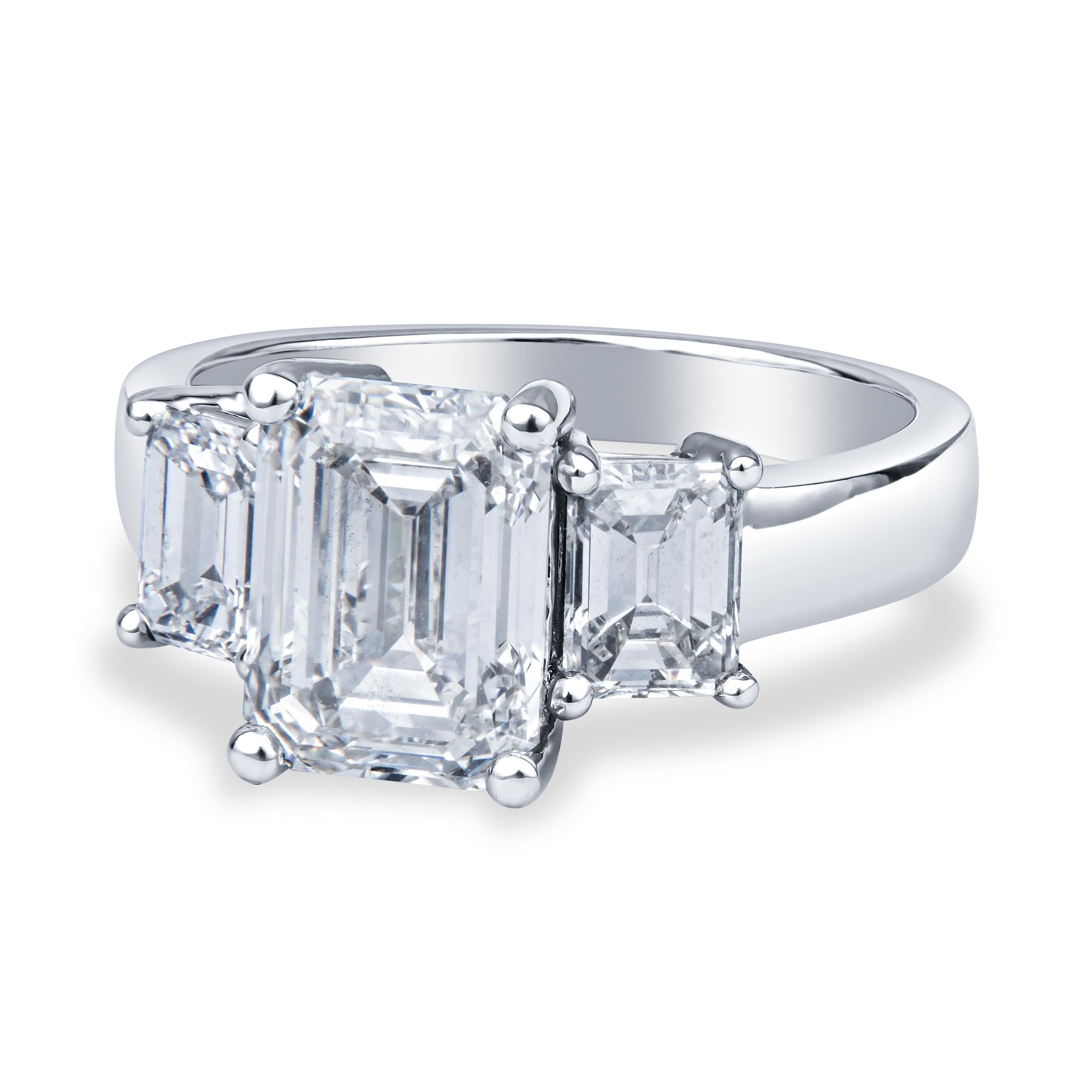 This stunning engagement ring features a 2.80ct, I VS1, emerald cut diamond in the center (GIA  3295775731), bordered by two 1.20ctw emerald cut side stones and set in a 5.25 platinum ring, which may be resized upon request.