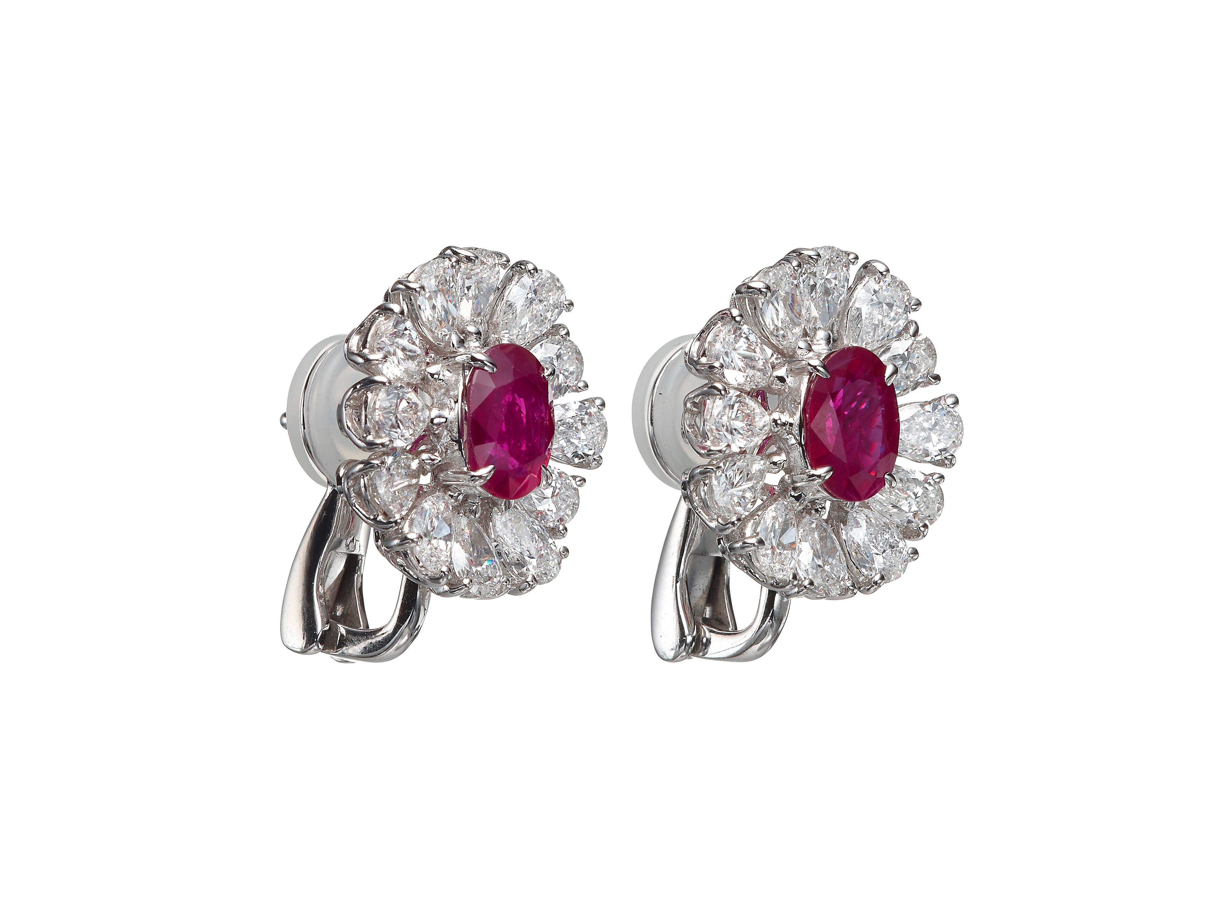 Understatedly elegant diamond stud earrings feature a center oval Ruby accented by a halo of pear-shape diamonds.  Total ruby weight 2.81 carats.  Total diamond weight 3.64 carats.  In 18k white gold.  This design is also available in Butani 2.5