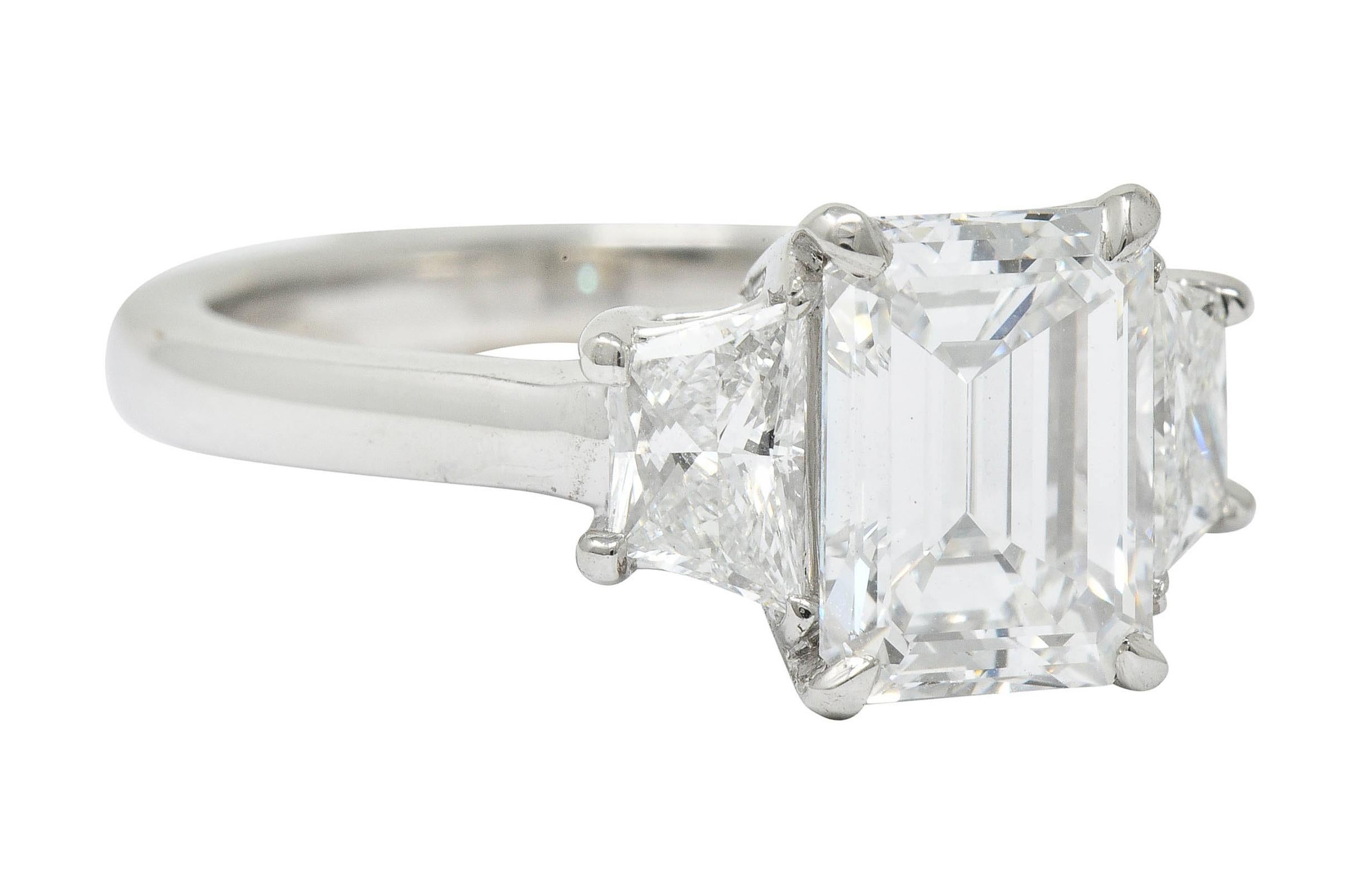 Centering a basket set emerald cut diamond weighing 2.01 carat; E color with VVS2 clarity

Flanked by two trapezoid cut diamonds weighing approximately 0.80 carat; F/G color with VVS clarity

Stamped Plat for platinum

Ring Size: 5 3/4 &