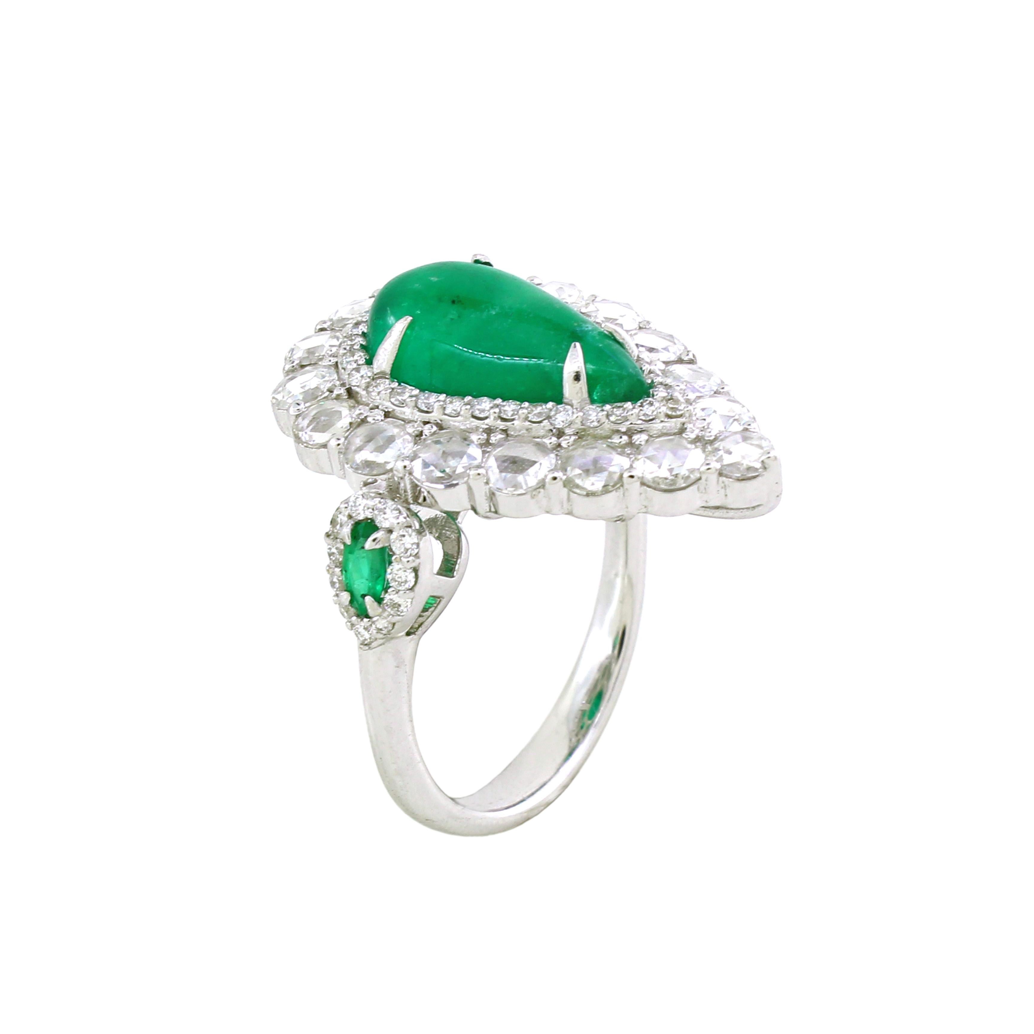 In der Mitte dieses exquisiten Cocktailrings befindet sich ein birnenförmiger Smaragdcabochon mit einem Gewicht von 2,63 Karat, der in einem satten Grünton erstrahlt, der das Wesen der natürlichen Schönheit einfängt. Der zentrale Smaragd ist von