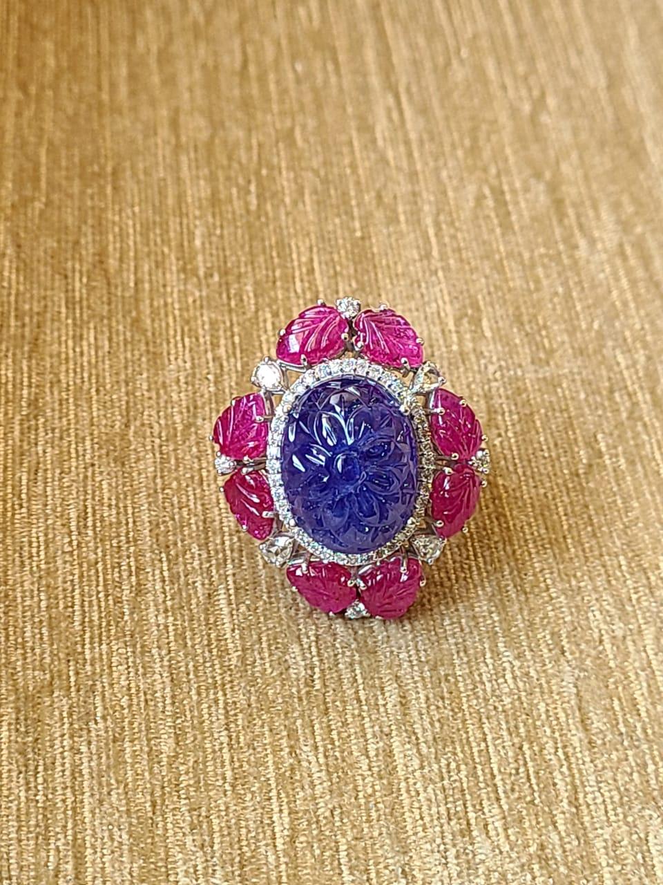 A one of a kind, Tanzanite & Ruby Cocktail/ Dome Ring set in 18K Gold & Diamonds. The weight of the carved Tanzanite is 28.17 carats. The Tanzanite is completely natural and hand-carved in our very own workshop. The Tanzanite is of Tanzania origin.