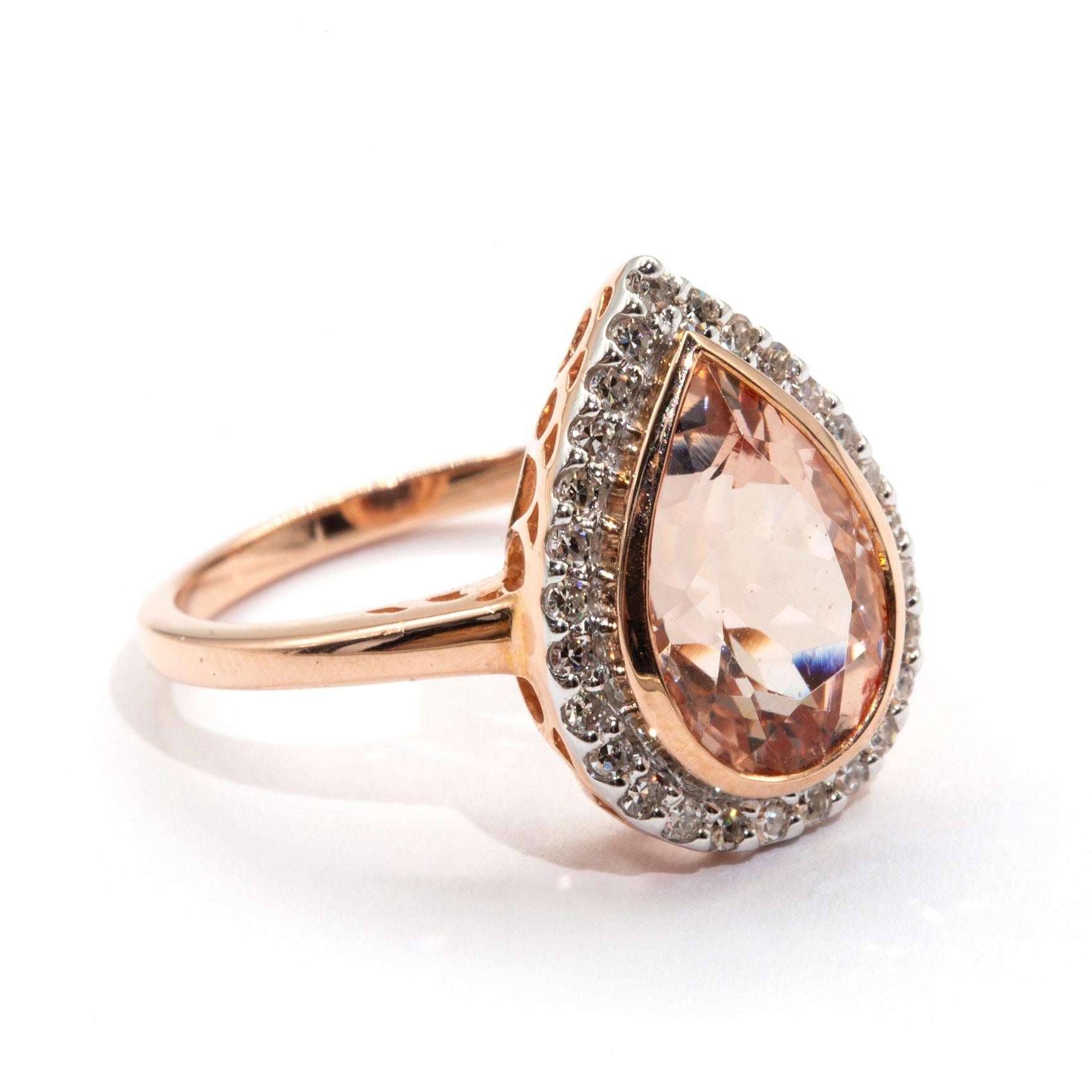 Made in 9 carat rose gold this wondrous vintage inspired ring boasts a romantic pear cut 2.82 carat bright light pink Morganite encompassed by a gorgeous halo border of carefully claw set round diamonds. We have named this alluring ring The Bella