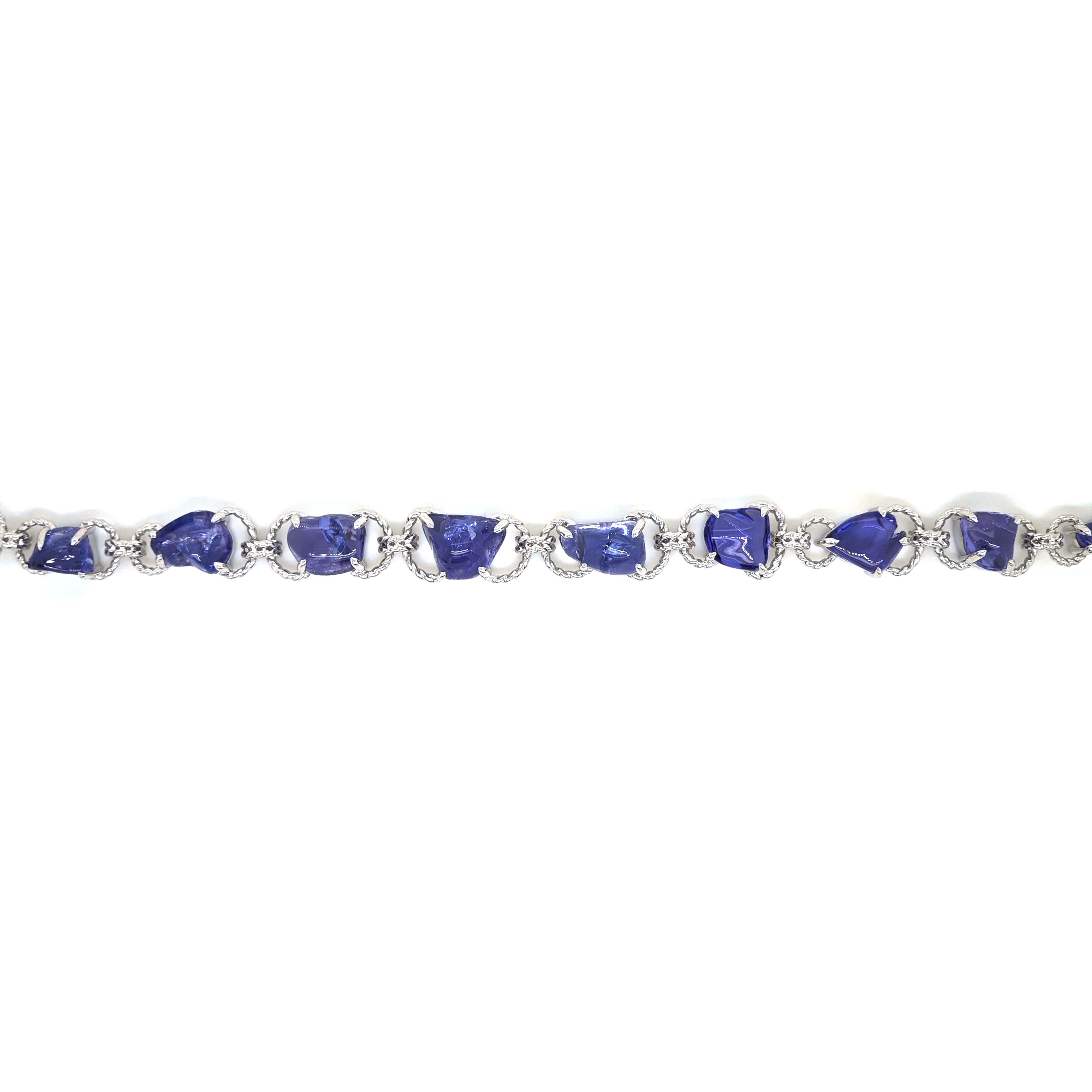 This beautiful bracelet with a twisted white gold link design features a series of tanzanite gemstones, each uniquely cut, set into each link. 

10 Gemstones: 28.25 Carats Tanzanite, Tumbled Cut
Metal: 18K White Gold, 17.40 Grams
