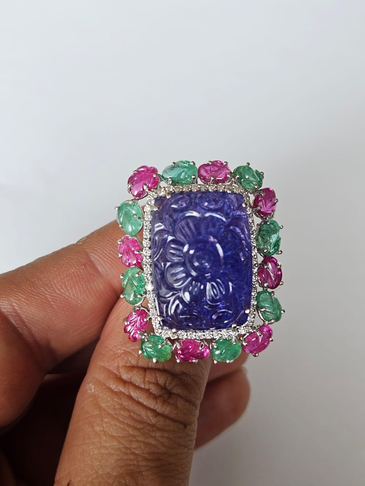 A very gorgeous and beautiful, Art Deco style, Emerald, Ruby & Tanzanite Tutti Frutti Cocktail Ring set in 18K White Gold. The weight of the carved Tanzanite is 28.28 carats. The Tanzanite is responsibly sourced from Tanzania & is expertly