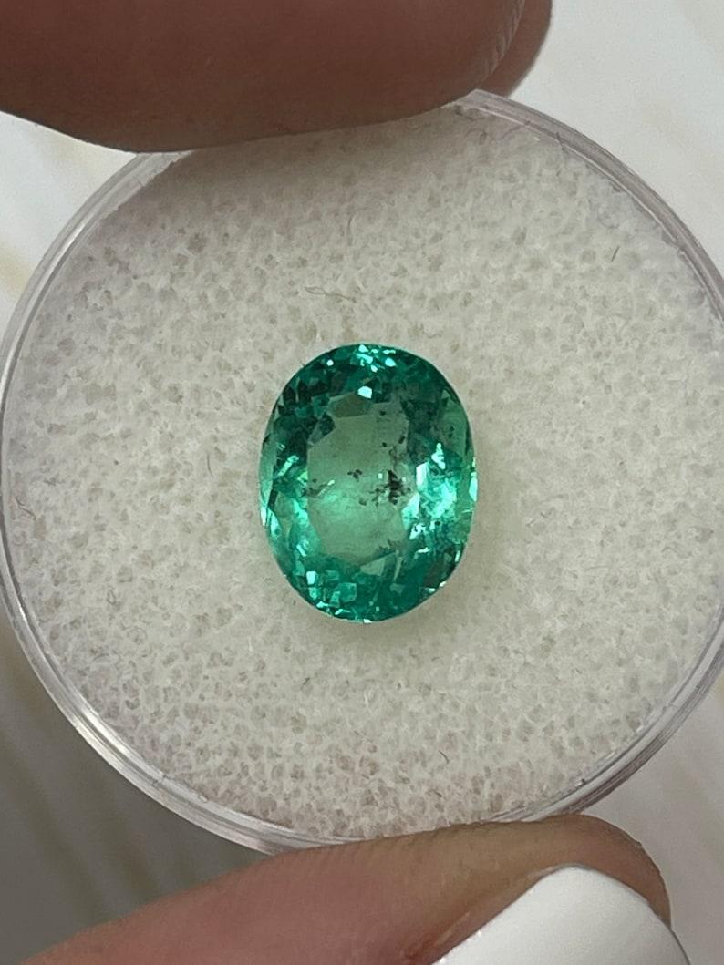 Modern 2.83 Carat 10x8mm Vibrant Freckled Green Colombian Emerald Oval Cut - May Births For Sale