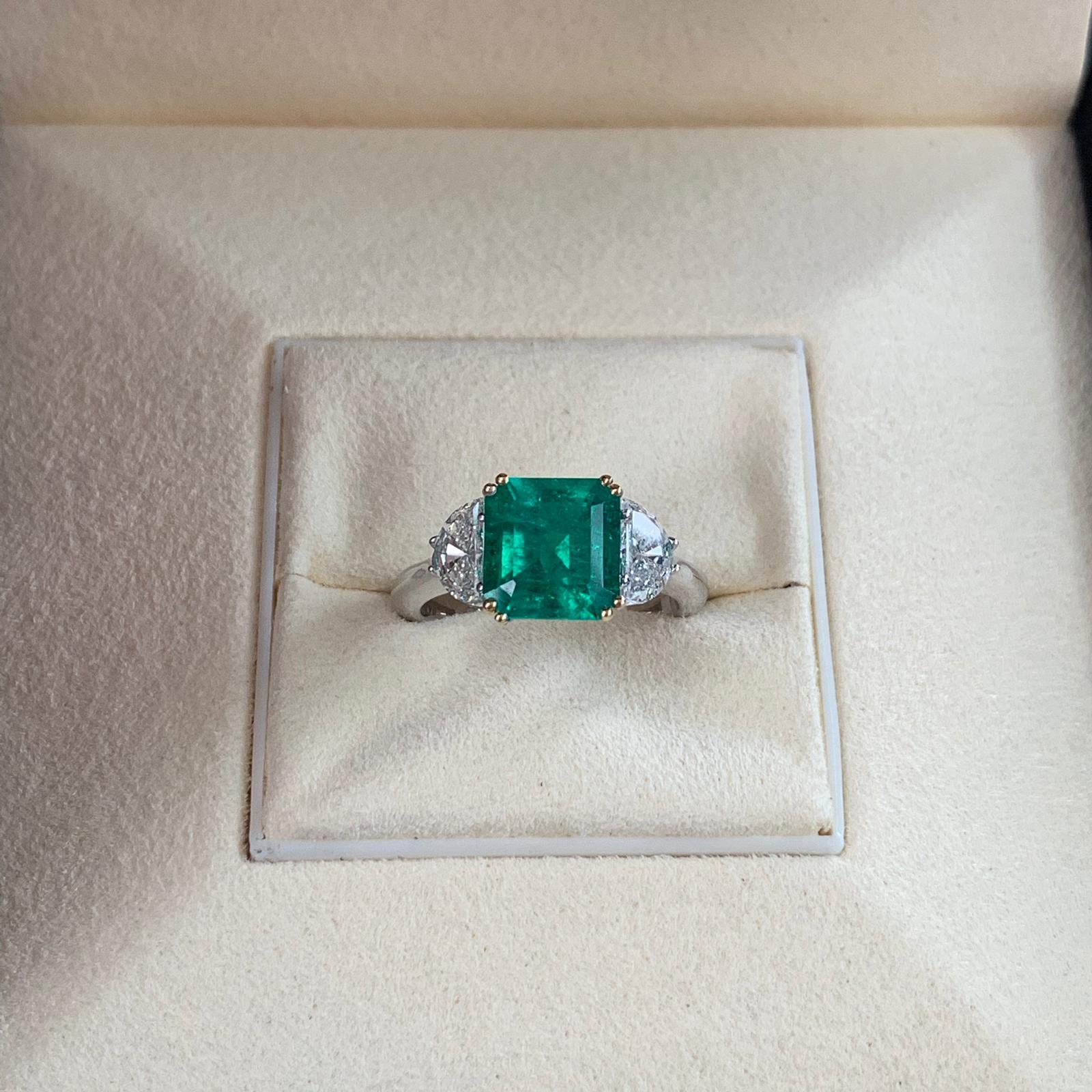 Beautiful 2.83 carats of Colombian Emerald, surrounded by 2 white trillion cut diamond 0.86 total carats. Set on 4 prong 18k white gold.