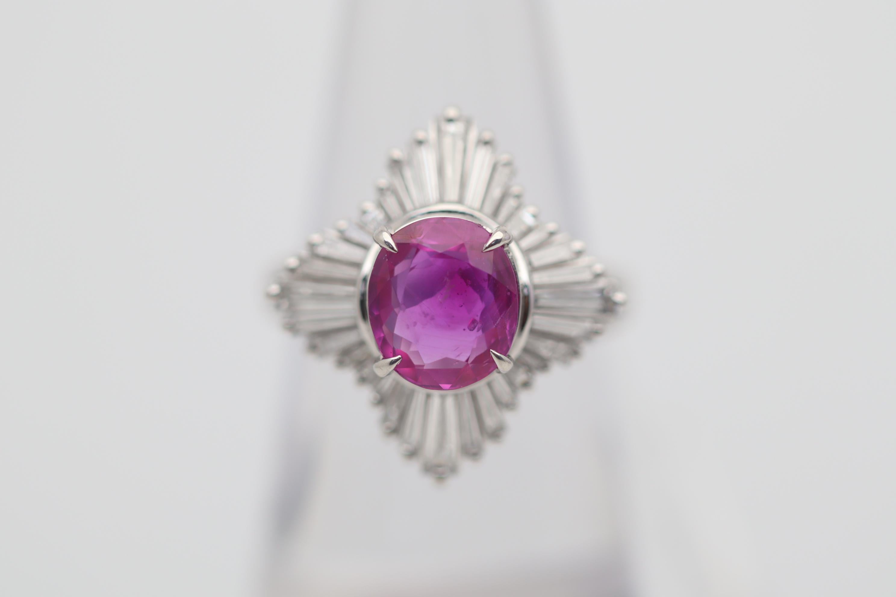 Ein besonderer Edelstein steht im Mittelpunkt dieses Diamant-Platinrings. Es handelt sich um einen 2,84 Karat schweren rosafarbenen Saphir mit einer satten, intensiven Farbe, die den Stein fast zu einem Rubin macht. Das Besondere an diesem Edelstein