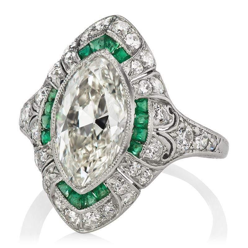 This ring is an authentic vintage ring from the Art Deco Era. The ring centers a GIA certified 2.84-carat Marquise cut diamond of I color, VS2 clarity. The stone is bezel-set in a platinum setting with calibre cut emeralds lining the stone and 32