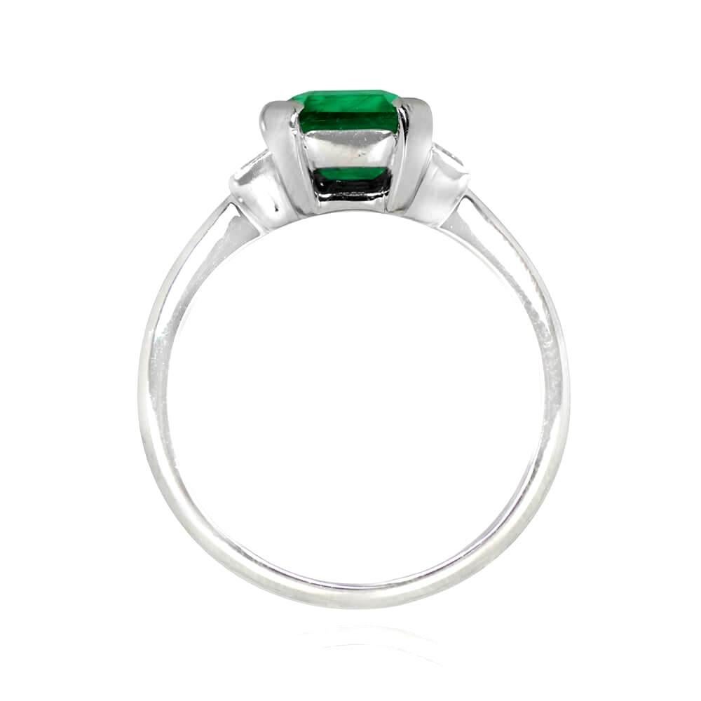 Crafted in platinum, this gemstone ring boasts a magnificent 2.84 carat emerald-cut emerald at its center, set in prongs and flanked by two baguette cut diamonds on the shoulders. The baguette cut diamonds weigh approximately 0.40 carats combined,