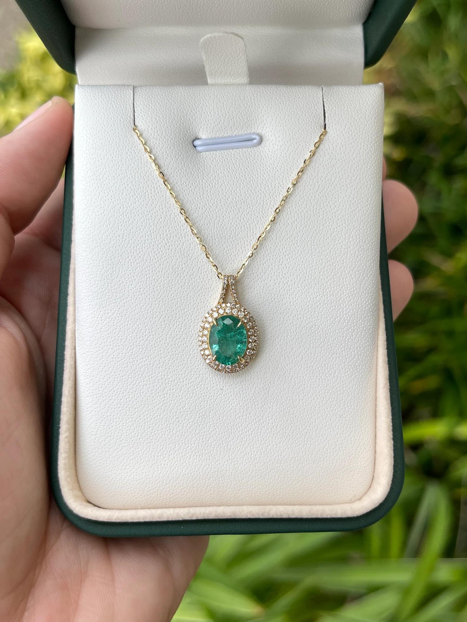 A stunning emerald and diamond pendant. This lovely piece showcases a 2.19-carat, natural Zambian emerald with a gorgeous medium bluish-green color, and great characteristics. Securely prong-set, in claws; surrounding this gem is a double halo of