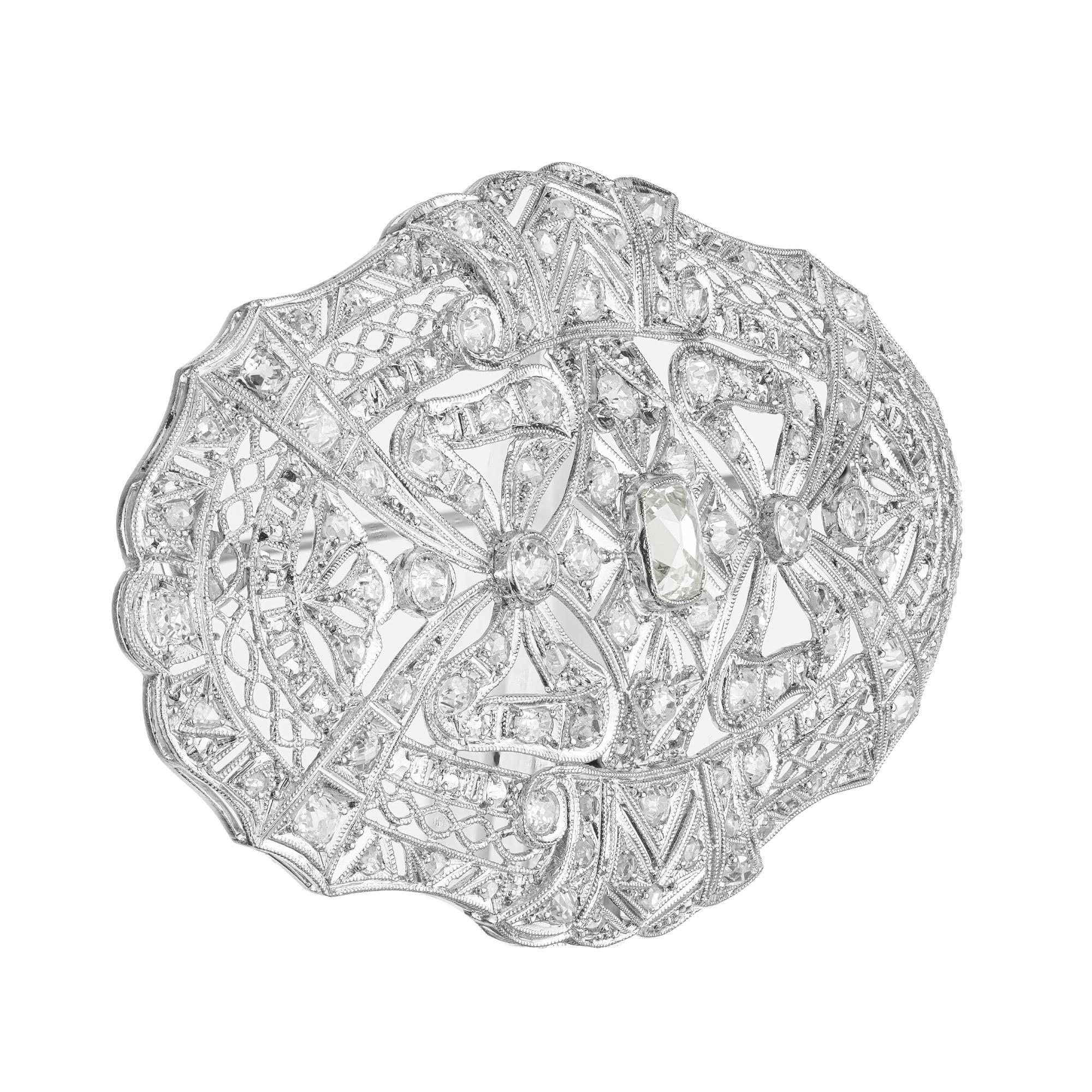 Bask in timeless elegance with our exquisite bow motif, 2.85 carat 1920's Art Deco diamond platinum oval filigree brooch. In the center is a 1.00ct cushion shape Old mine cut diamond. Mounted in a filigree open work setting with a beading and