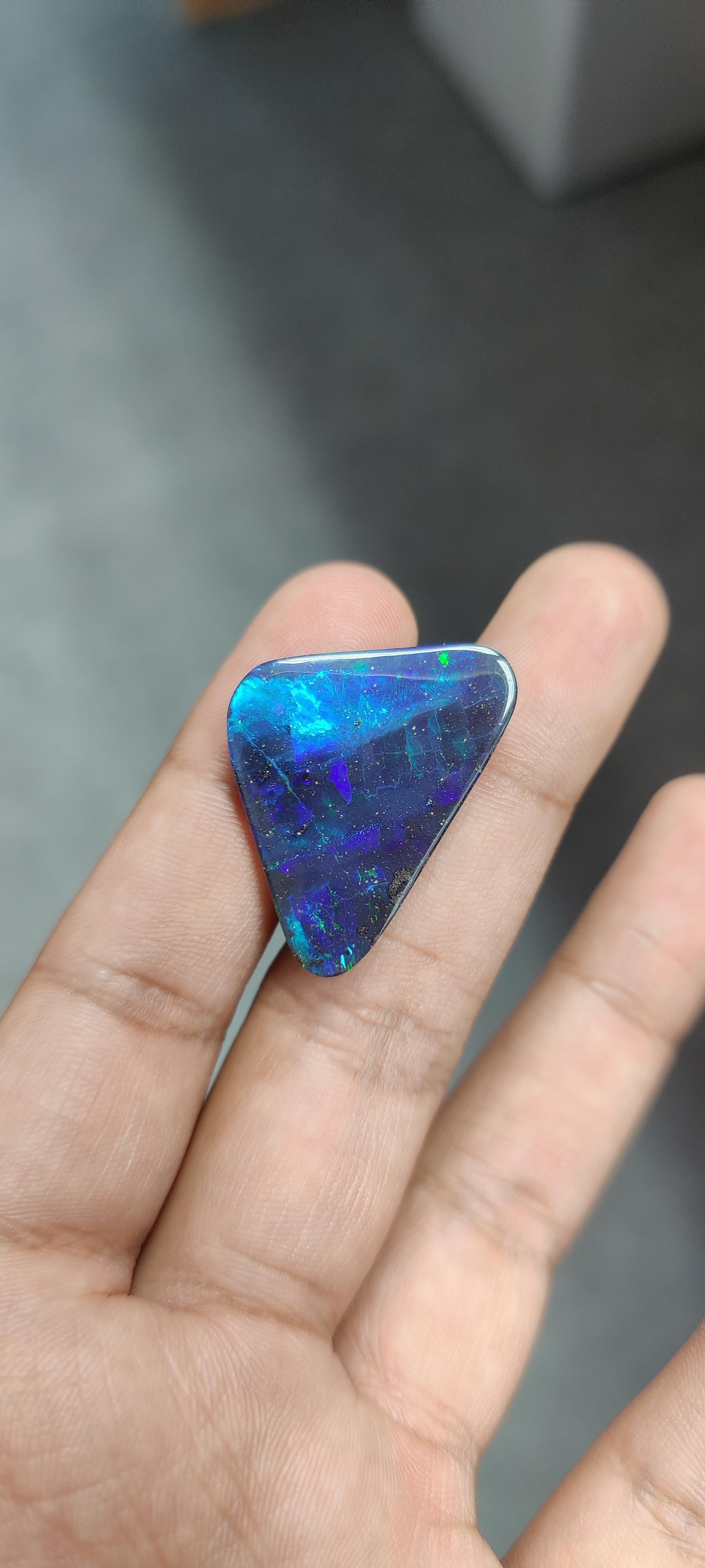 Questo pezzo è un enorme e stupefacente opale nero da 28,57 carati, con un'affascinante forma a trilione. L'opale è una gemma unica e affascinante, nota per i suoi giochi di colore, ovvero una serie mutevole di sfumature dell'arcobaleno che sembrano