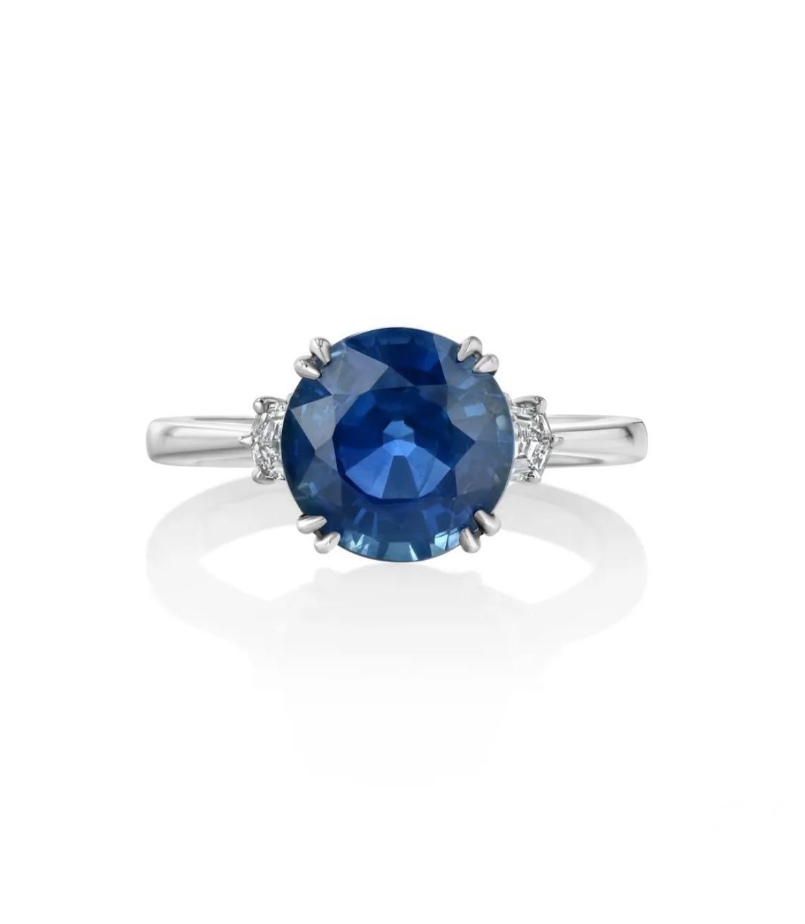 Platinum ring, featuring a 3.85-carat, GIA certified blue sapphire, flanked by two cadillac-cut diamonds. 