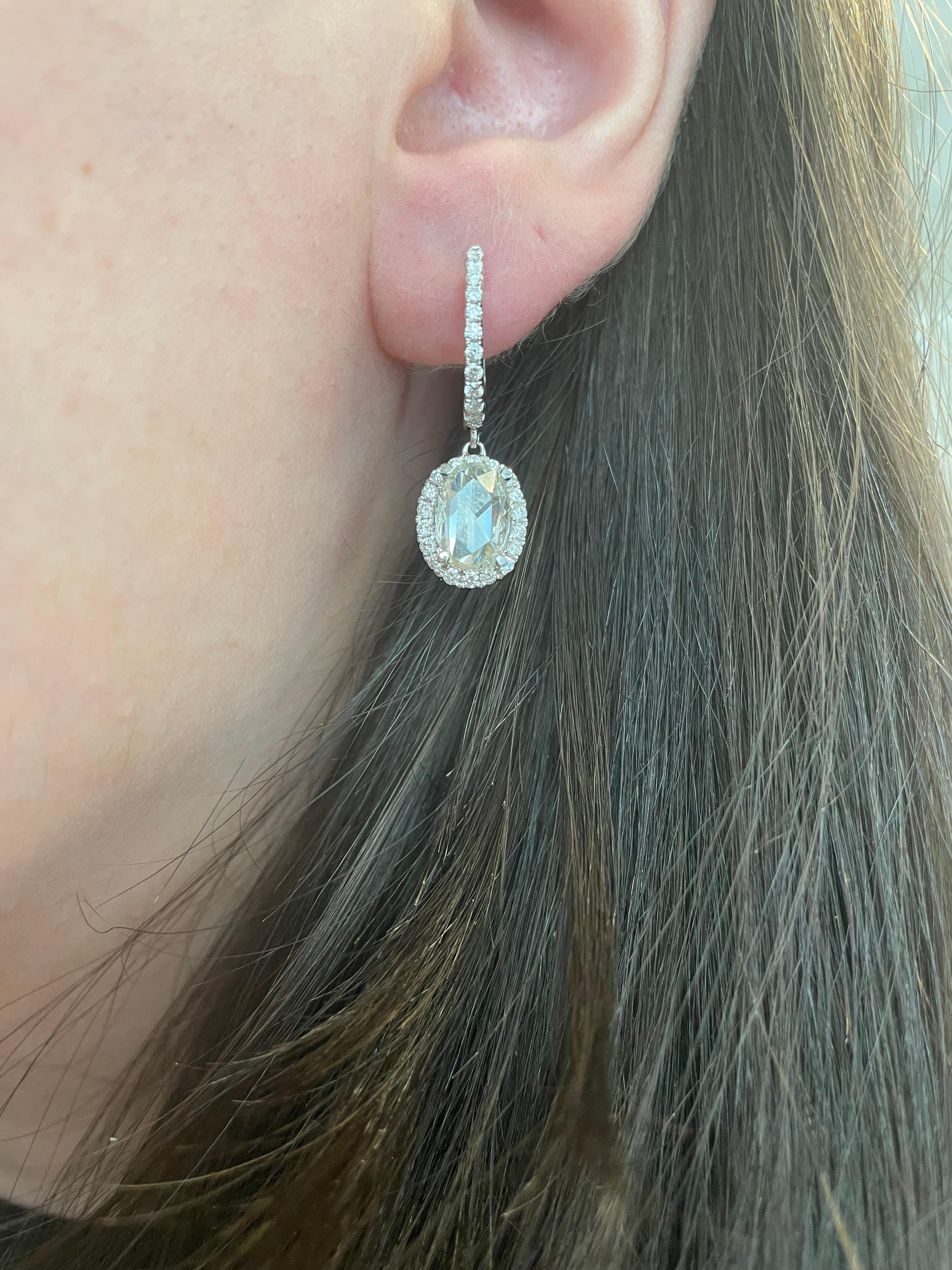 Unique modern oval rose cut diamond with halo drop earrings.
2 oval rose cut diamonds, 2.85 carats. Approximately I/J color and VS2/SI1 clarity. Complimented by 58 round brilliant diamonds, 0.72 carats. Approximately G/H color and SI clarity. 18k