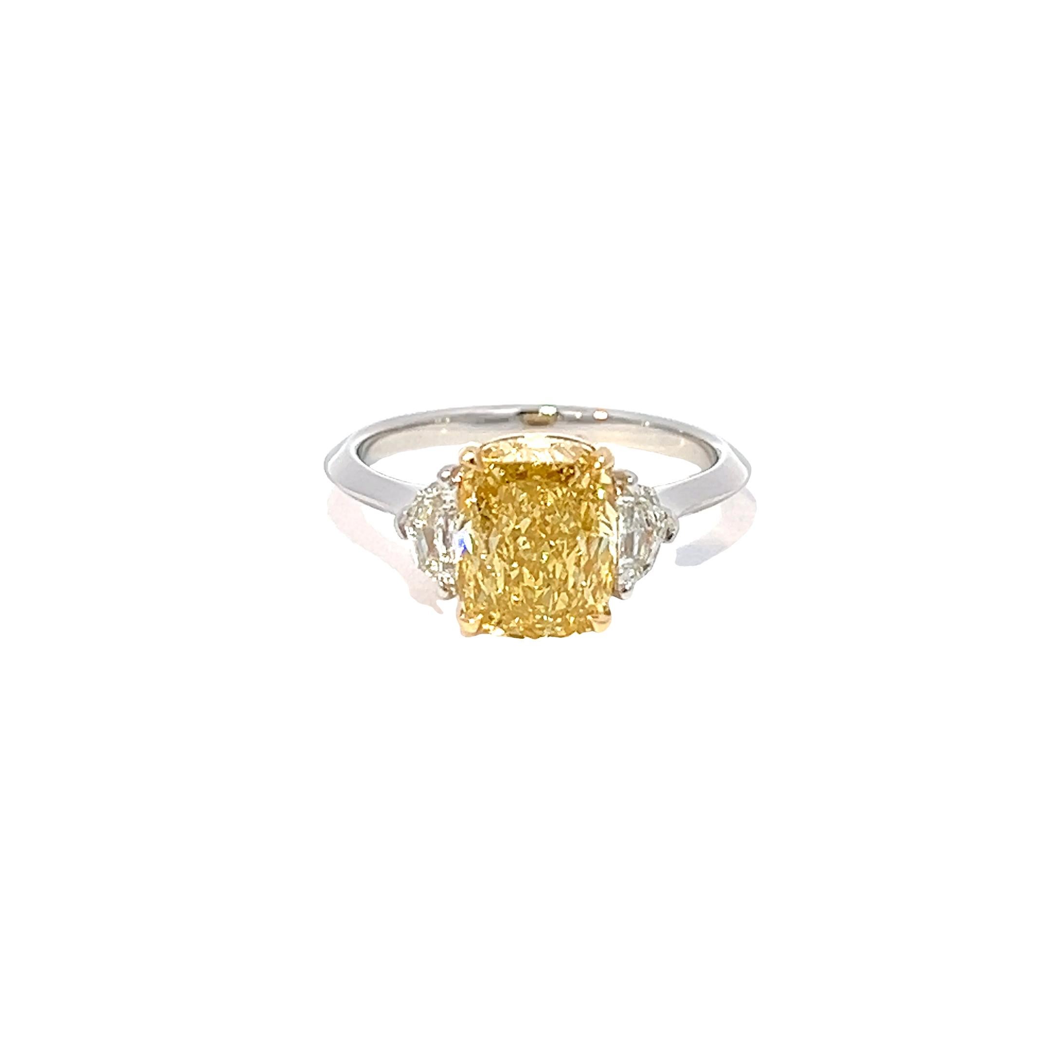 Behold, an exquisite diamond engagement ring, meticulously crafted to perfection! It boasts a spectacular 2.50CT Fancy Intense Yellow Diamond at the center, with SI1+++ clarity, set in 18K Yellow Gold. The center stone is flanked by two diamonds on