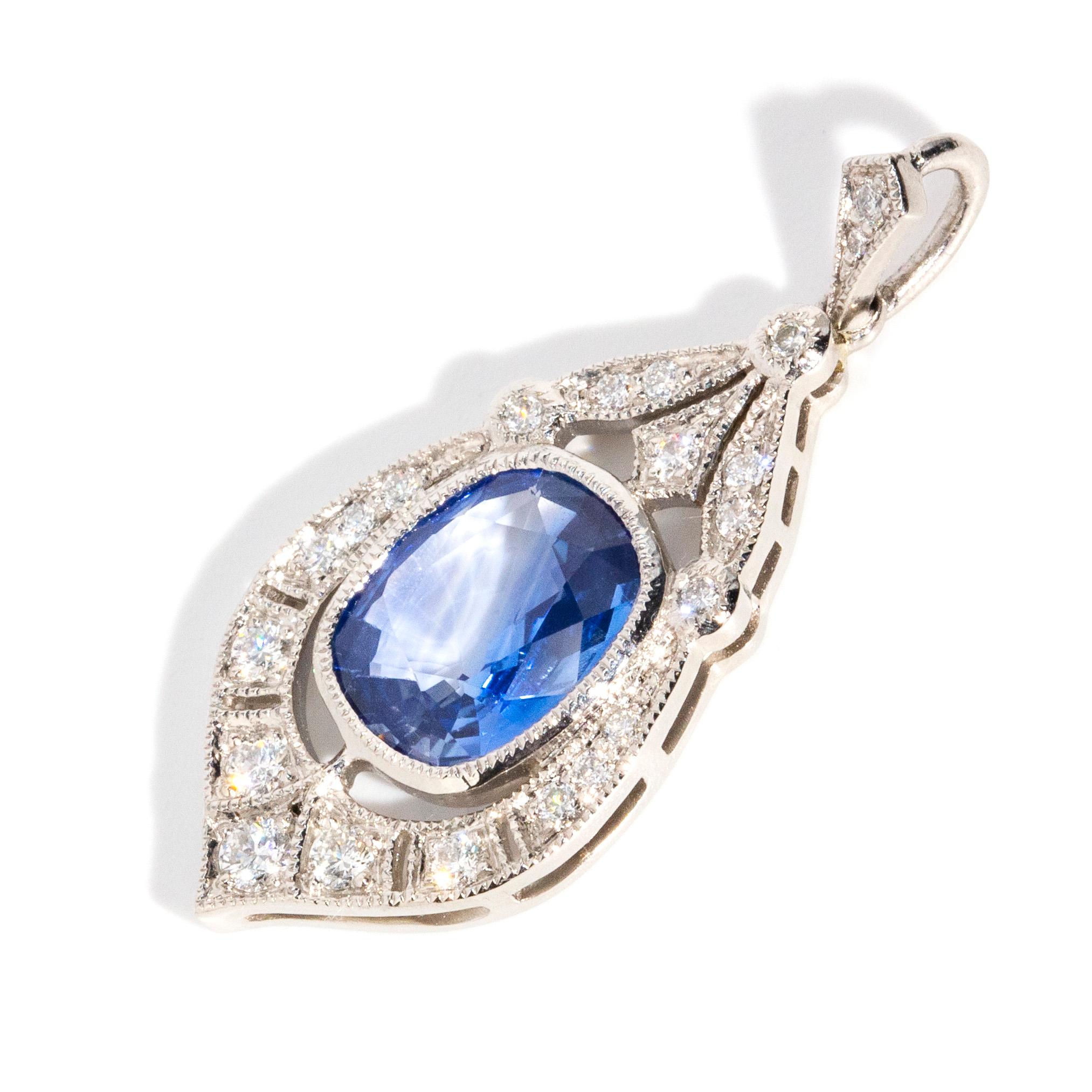 Crafted with devotion, this stunning art deco-inspired platinum milgrain pendant holds a stunning cushion-shaped Ceylon sapphire at the centre. A plethora of carefully set shimmering round brilliant cut diamonds decorate the gorgeous frame and bail,