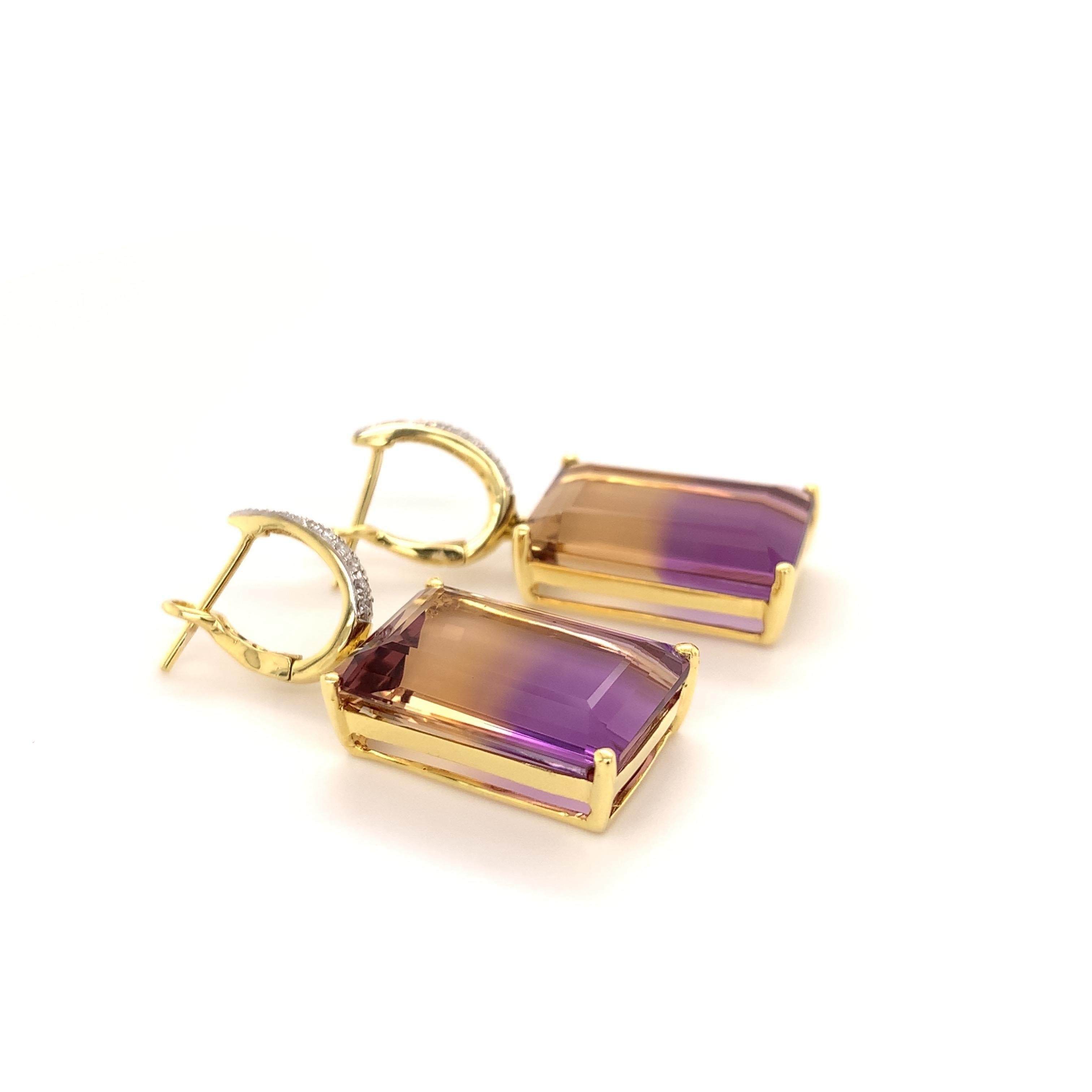 Stunning ametrine diamond dangling earrings. Golden honey tone with a rich purple tone, transparent, emerald faceted, natural 28.7 carats matching ametrine, accented with round brilliant cut diamond on the dangling bail. 
Handcrafted design set in