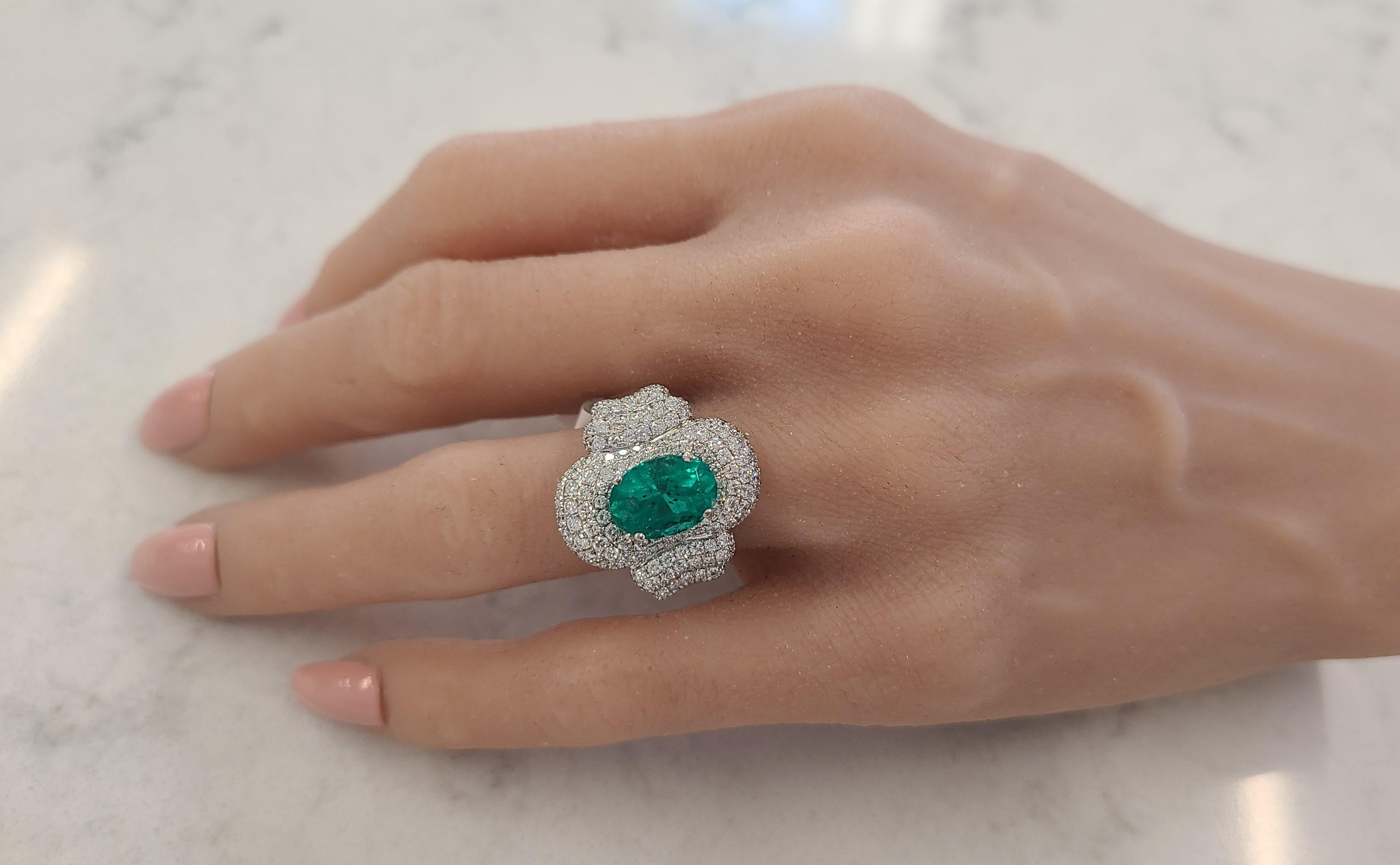 Created in brightly polished 18k white gold, this custom-made emerald and diamond ring is truly one-of-a-kind in sophisticated style. An oval cut emerald sits nestled in a four prong setting with a weight of 2.87 carats and measurements of