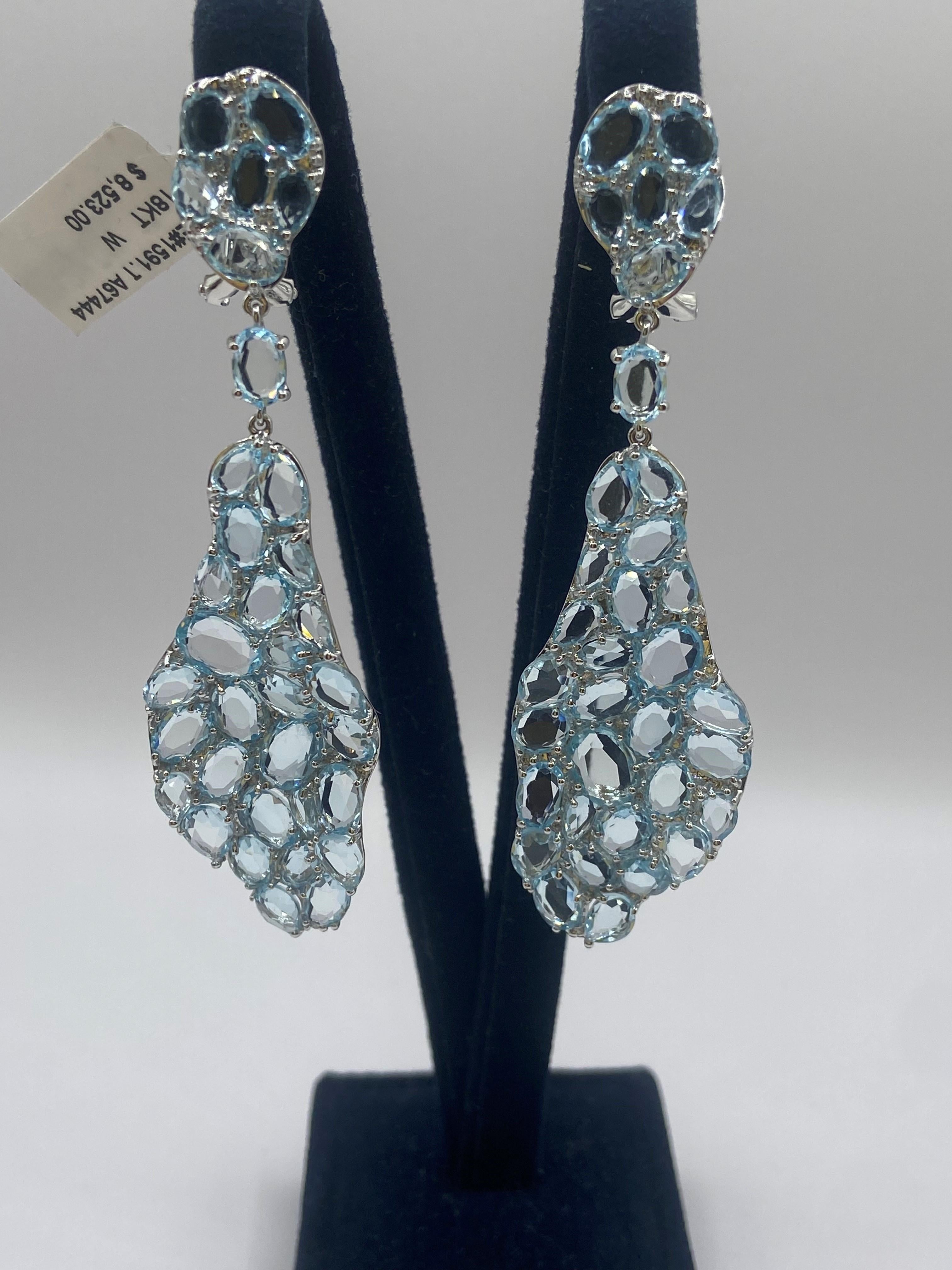 •	18KT White Gold
•	28.74 Carats

•	24 Round Diamonds: 0.13ctw
•	Color: F
•	Clarity SI1

•	Number of Rose Cut Blue Topaz: 68
•	Carat Weight: 28.61ctw

This pair of earrings is made with 68 rose cut light blue topaz stones, weighing 28.61 carats. The
