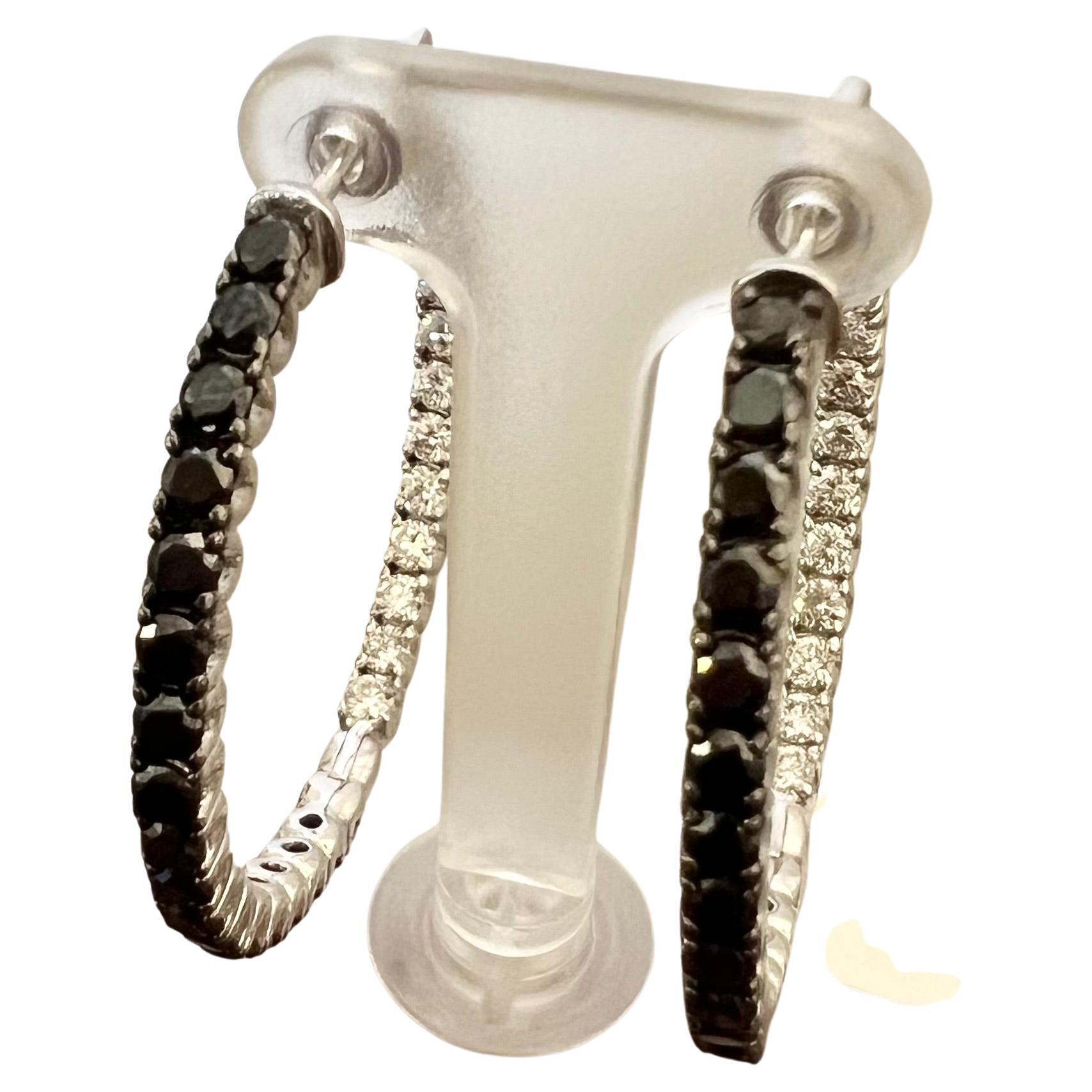 These gorgeous hoop earrings have 1.68 carats of Natural Round Cut Black Diamonds and 1.20 carats of Natural Round Cut White Diamonds. The total carat weight of the earrings are 2.88 carats. 

The hoop earrings measure at approximately 1.5 inches