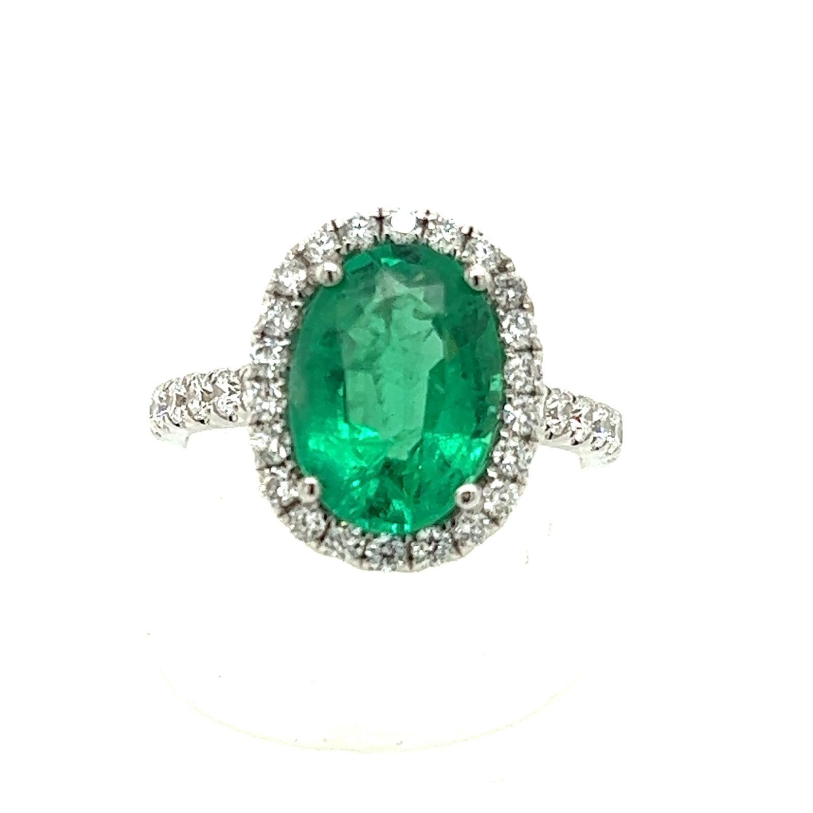 Oval emerald weighing 2.88 carats
Diamonds weighing .69 cts
Halo style ring. 
Zambian origin
18 karat white gold