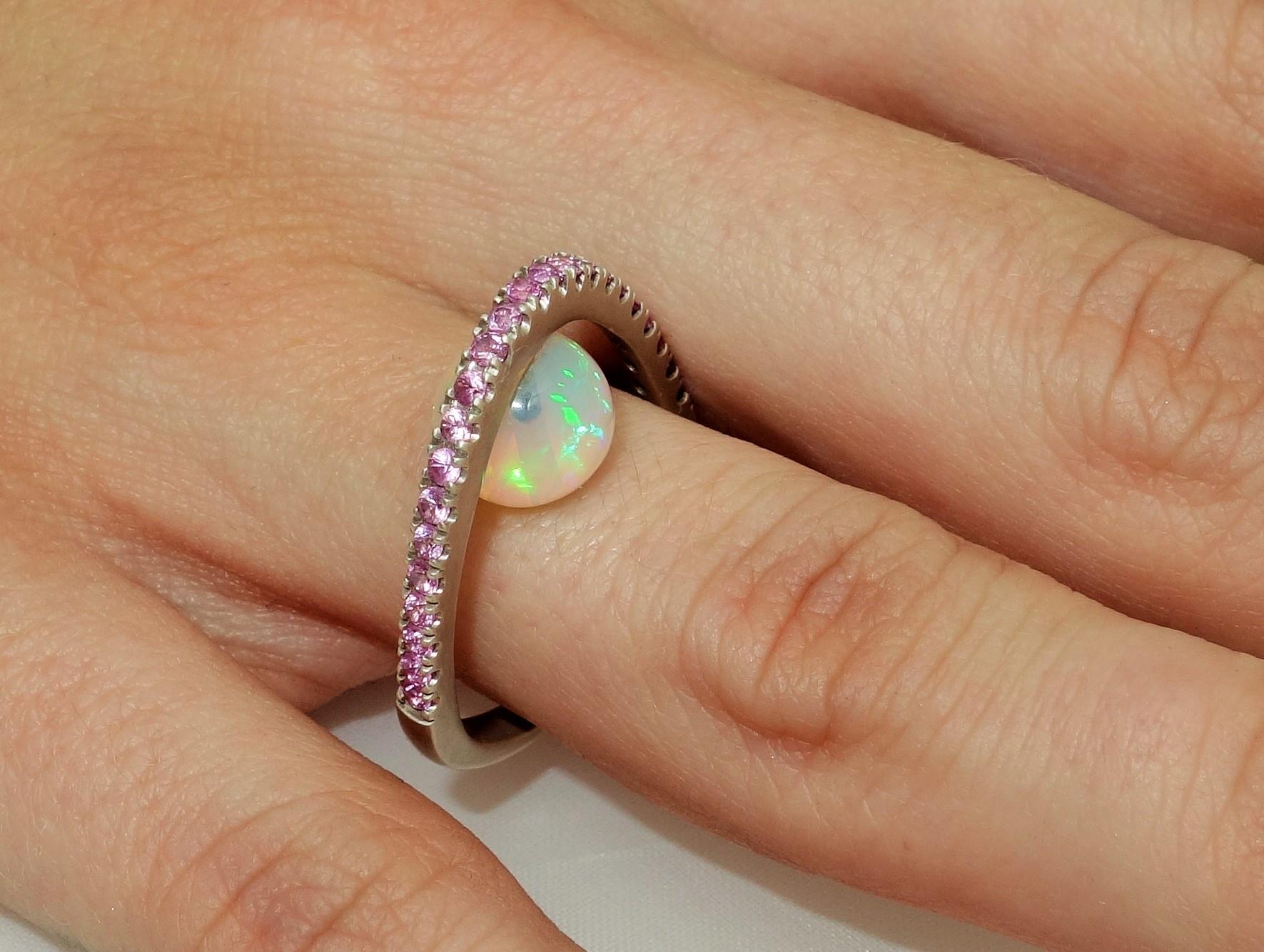 Top of ring set with Pink Sapphires, featuring a 2.88 Carat Ethiopian Opal below; Pink Sapphires approx. .70tctw; Sterling Silver Tarnish-resistant Rhodium mounting; Size 7, we offer ring re-sizing. More fabulous in person...A Striking Statement,