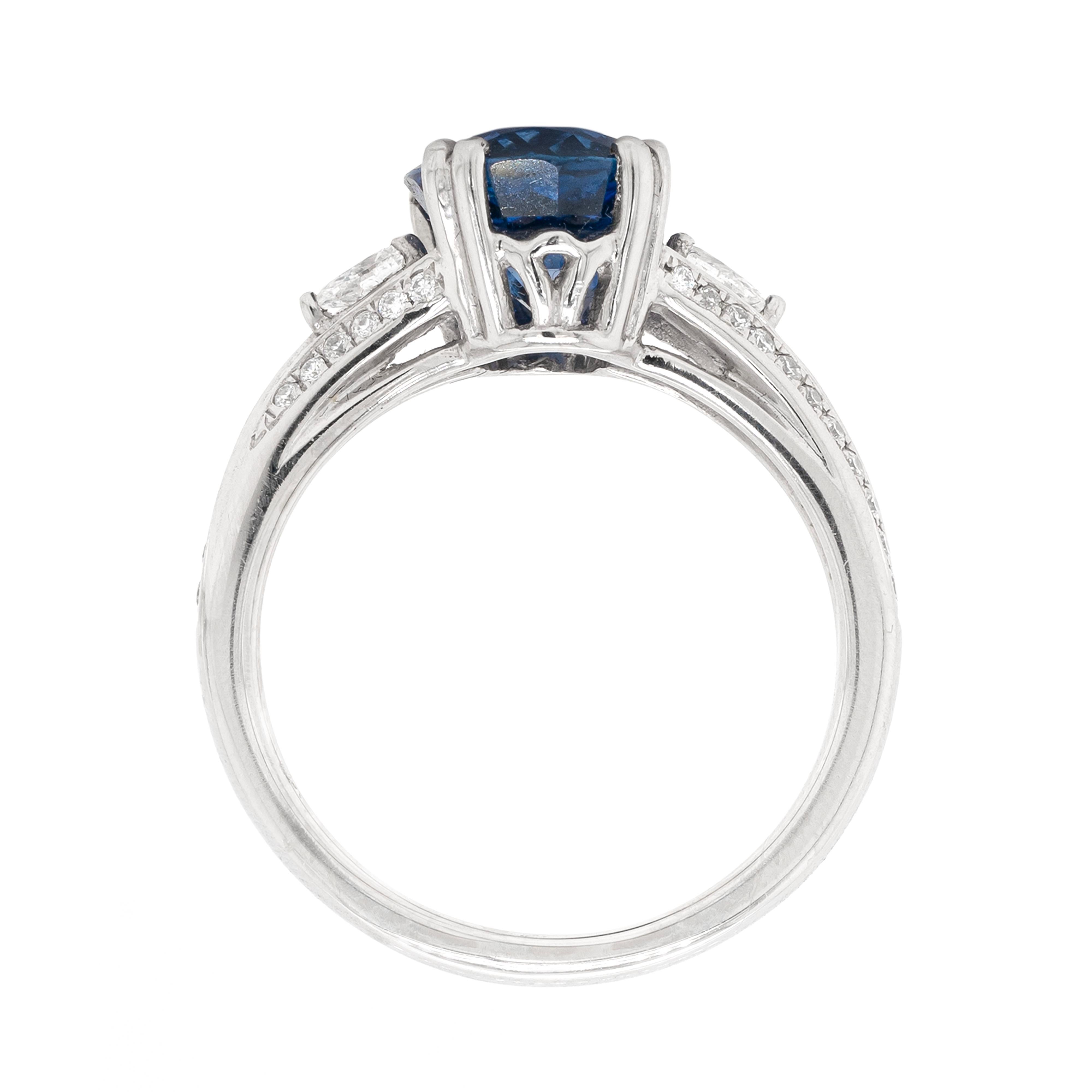 This wonderful platinum engagement ring features a gorgeous 2.88ct royal blue oval sapphire, mounted in a four double claw, open back setting. The vibrant gemstone sits atop an exquisite diamond set split shoulder shank and is beautifully