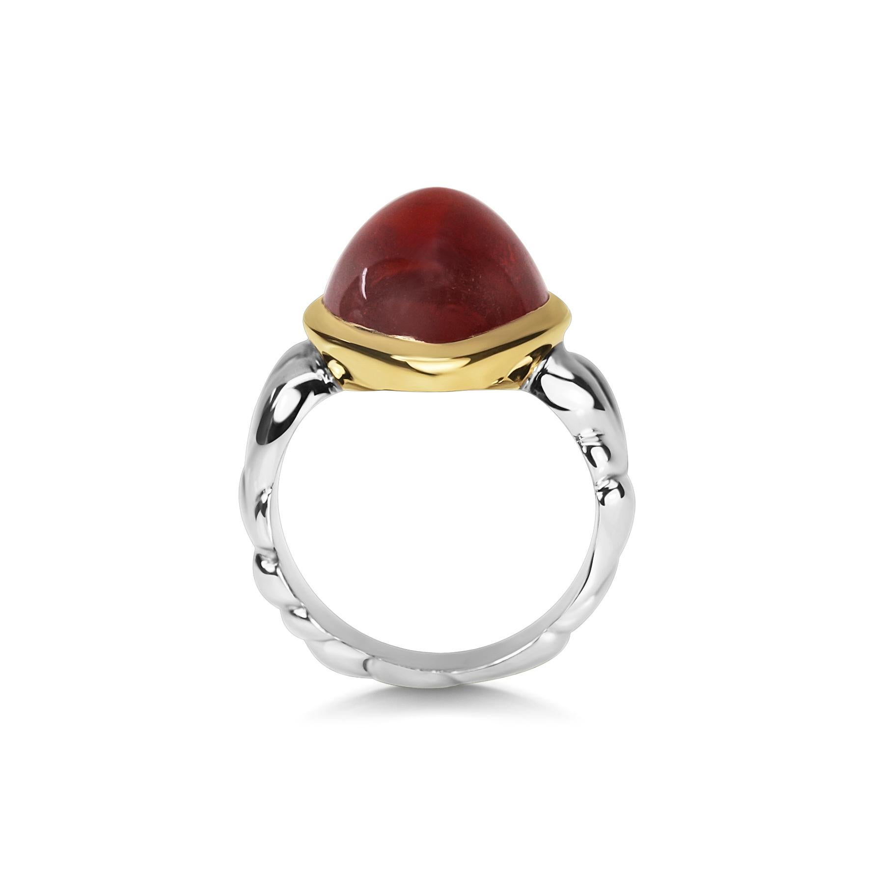 Large spessartite garnet cabachon stone with a high peaked top. The gemstone is set in 18k yellow gold, and held in a 18k white gold carved band. 

The spessartite garnet has a wonderfully warm and rich autumn tones - orange, brown and red. It has