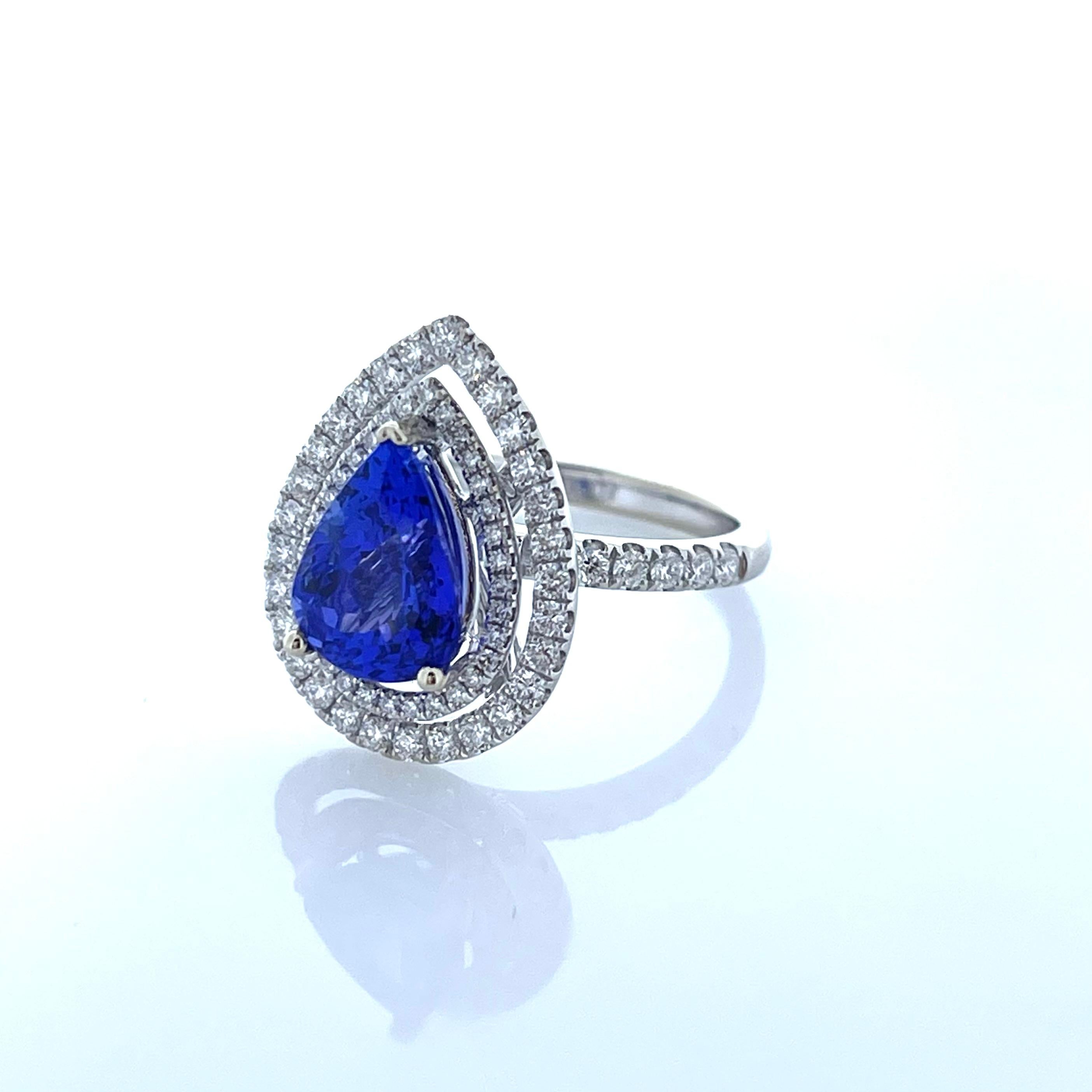 A gorgeous intense Bluish violet sugar loaf tanzanite is prong set in the center with a weight of 2.89 carats. This spectacular 18 karat white gold custom made ring truly displays the incredible beauty of the Pear shaped tanzanite. The 1.14 carat