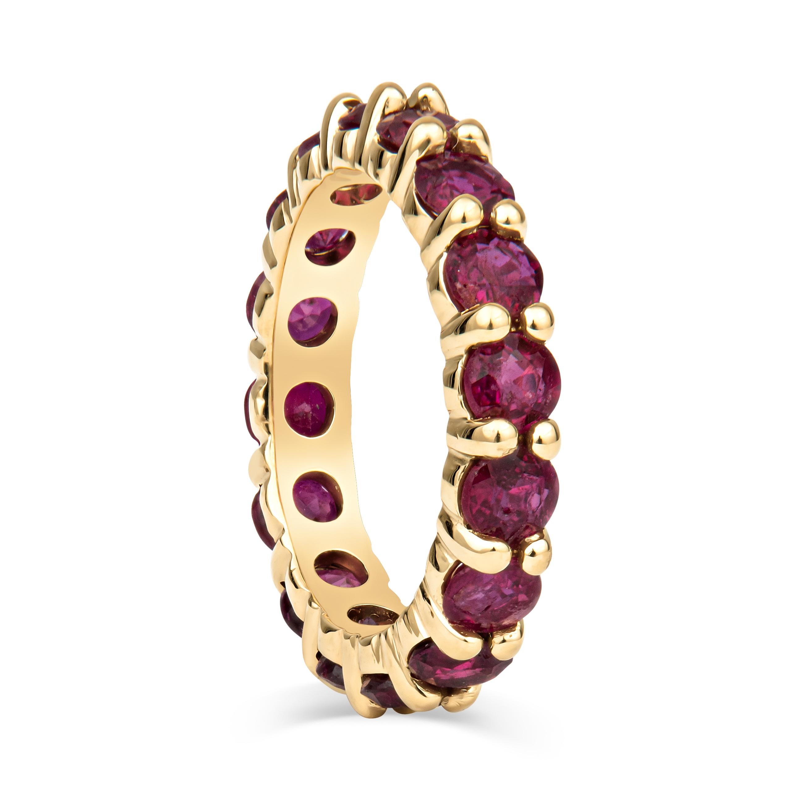 This incredible stacking band features 2.89ct total weight in beautiful, vivid red natural rubies, set in an 18kt yellow gold shared prong eternity band. The yellow of the ring complements the warm tones of the ruby, making the color stand out more.