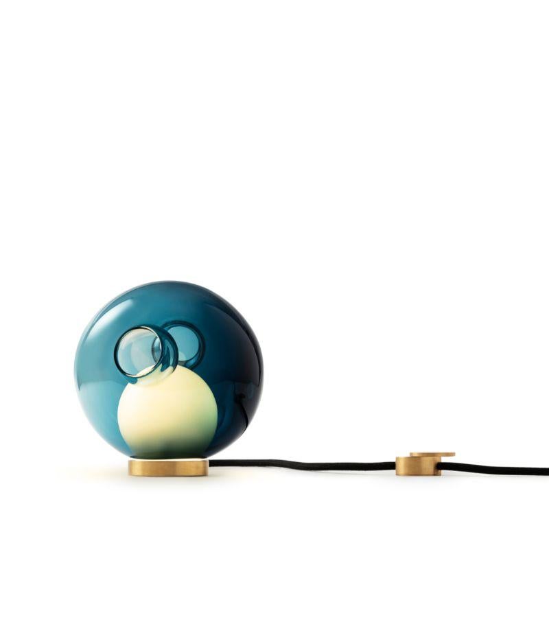 28t color table lamp by Bocci
Dimensions: Diameter 16.5 x Height 16.5 cm 
Materials: blown glass, black flexible cord with brass base and dial control
Lamping: : 1.5w LED. Non-dimmable. 
Cable Lenght: 229 cm 
Available in colors: Blue, Smokey,