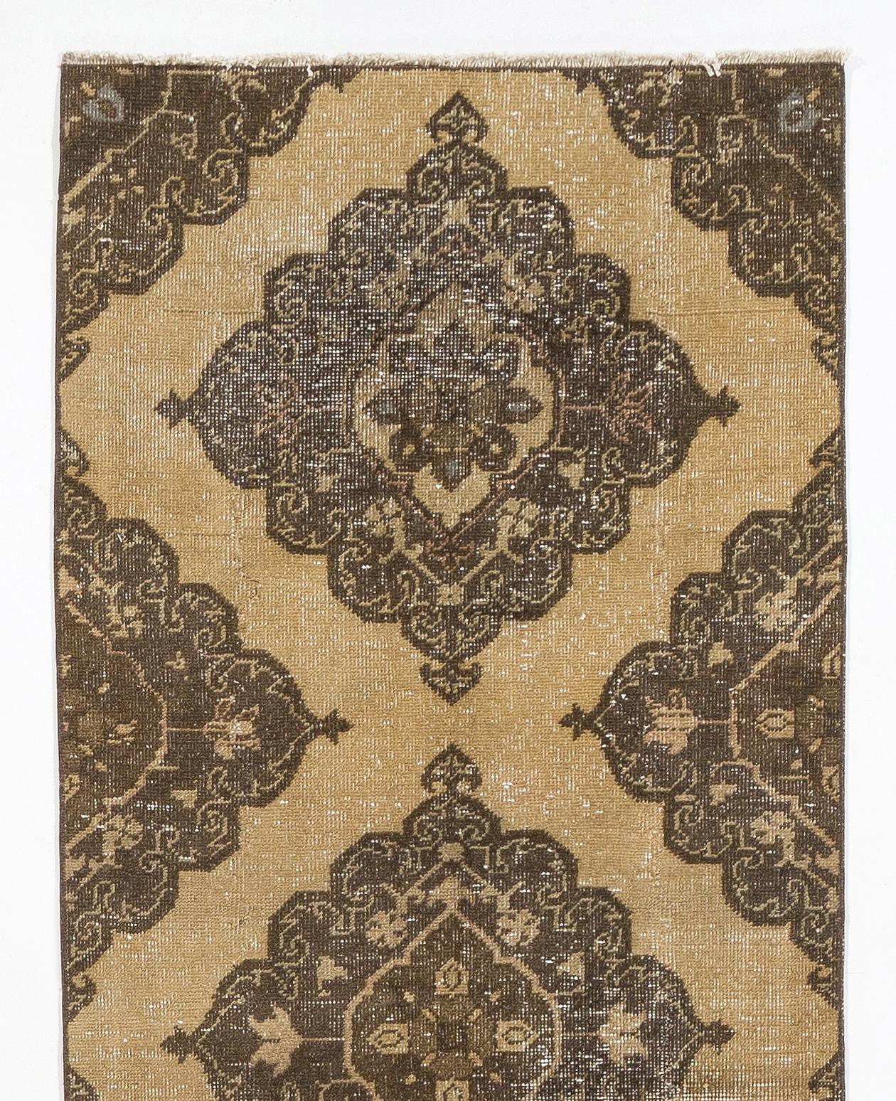 A vintage Turkish runner rug in beige and brown colors. It was hand-knotted in the 1960s with low wool on cotton foundation and features a multiple geometric medallion design. It is in very good condition, professionally-washed, sturdy and suitable